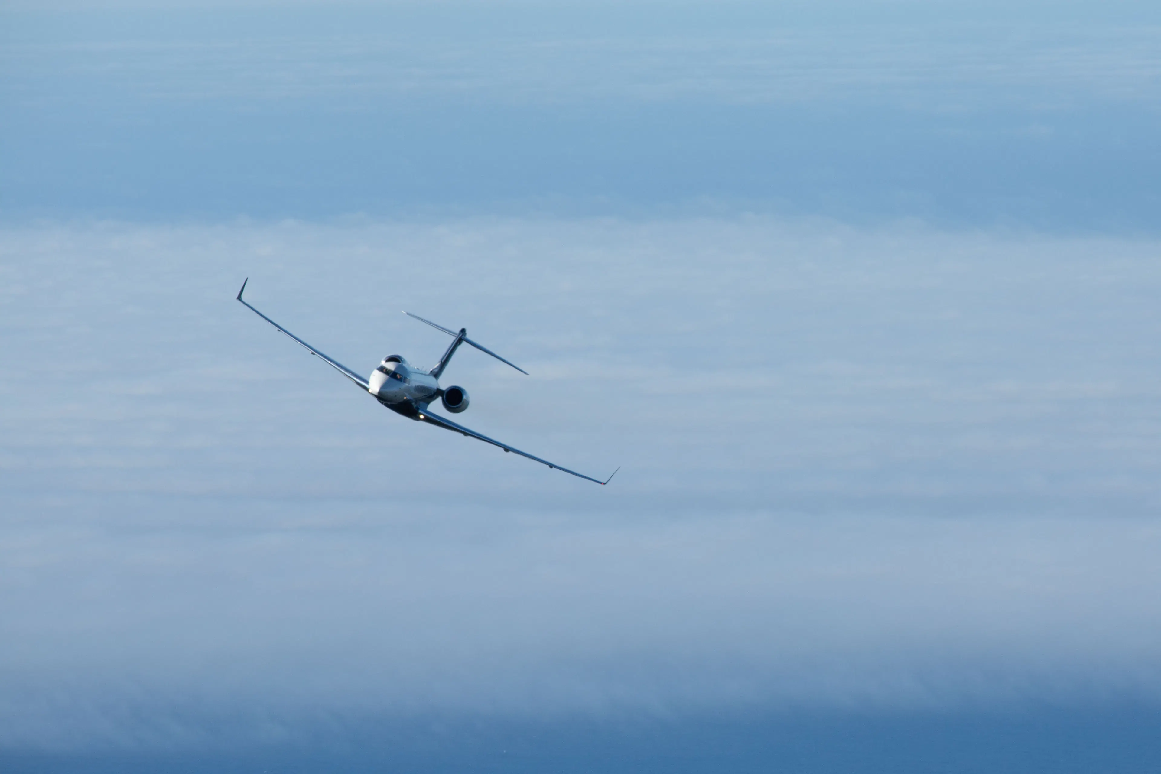 Private jet flying above the clouds