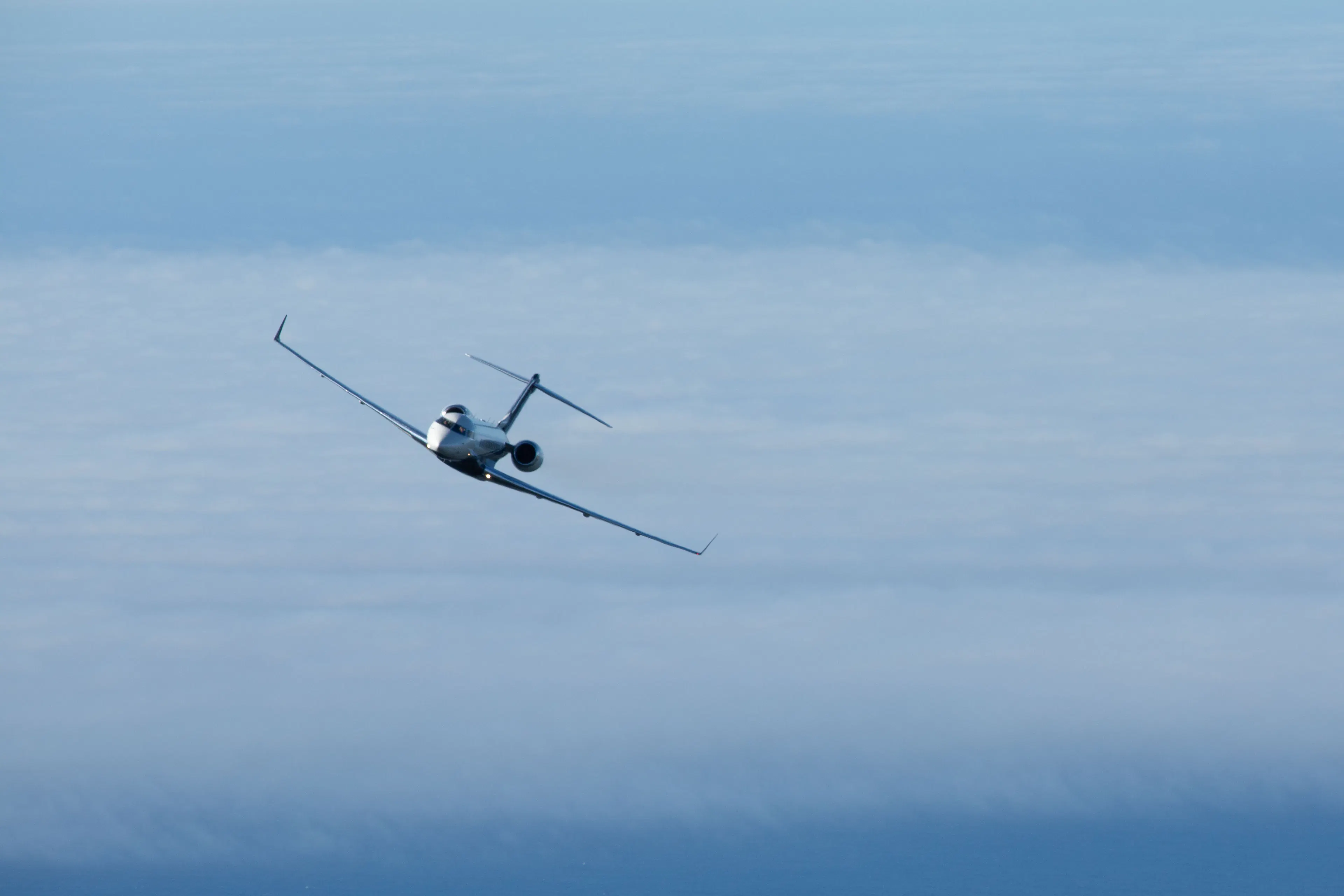 Private jet flying above the clouds