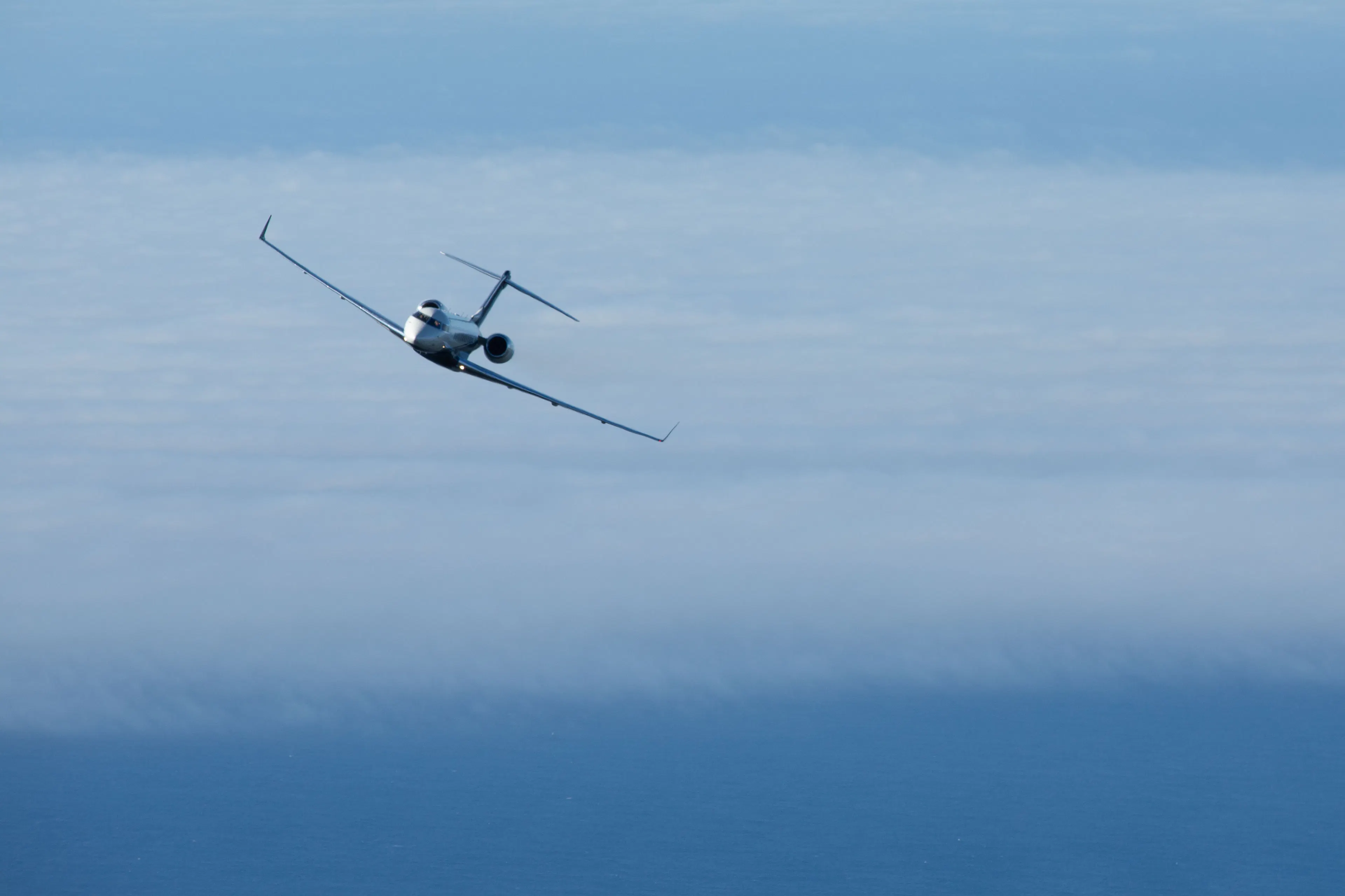 Private jet flying above the clouds