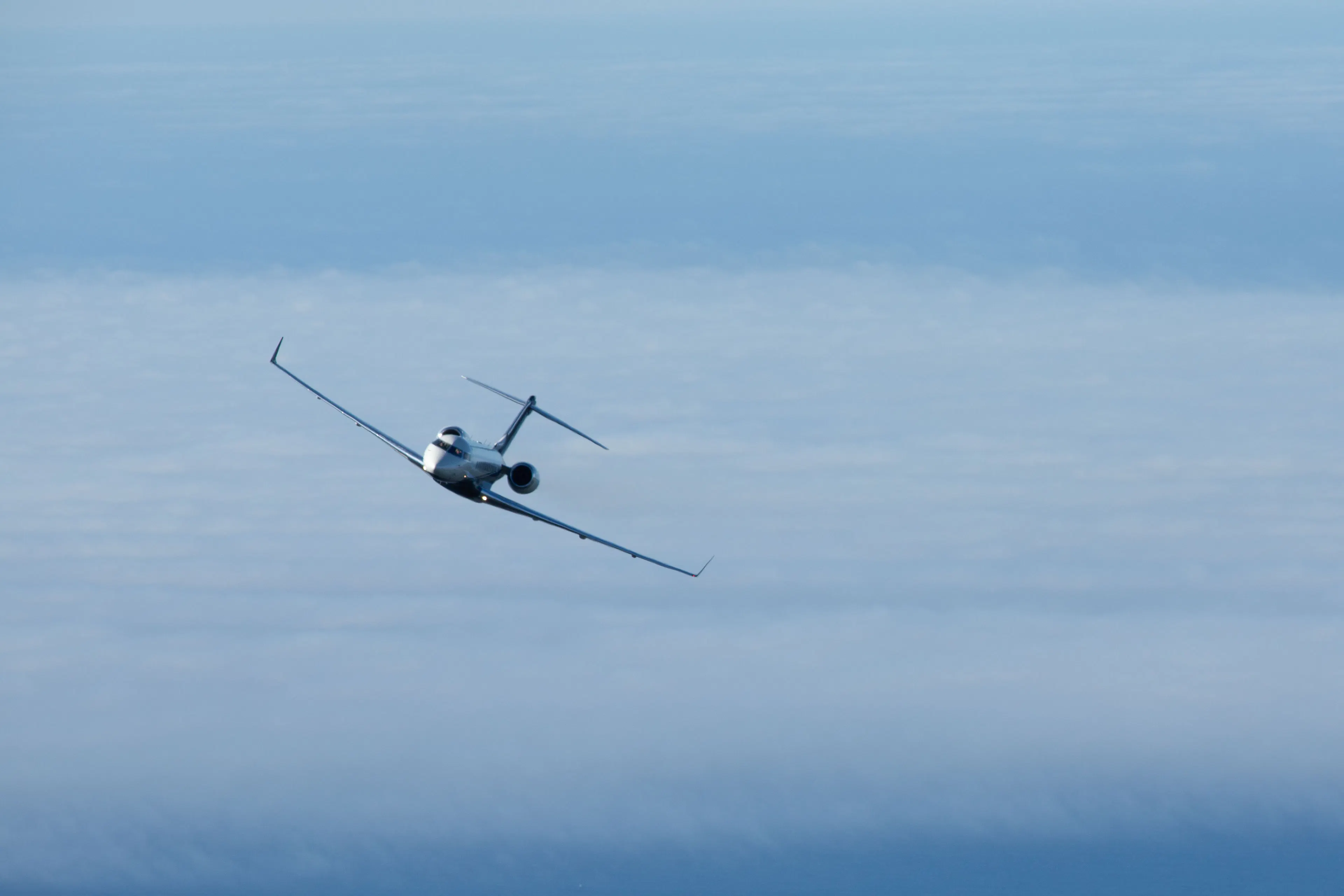 Private jet flying above the clouds