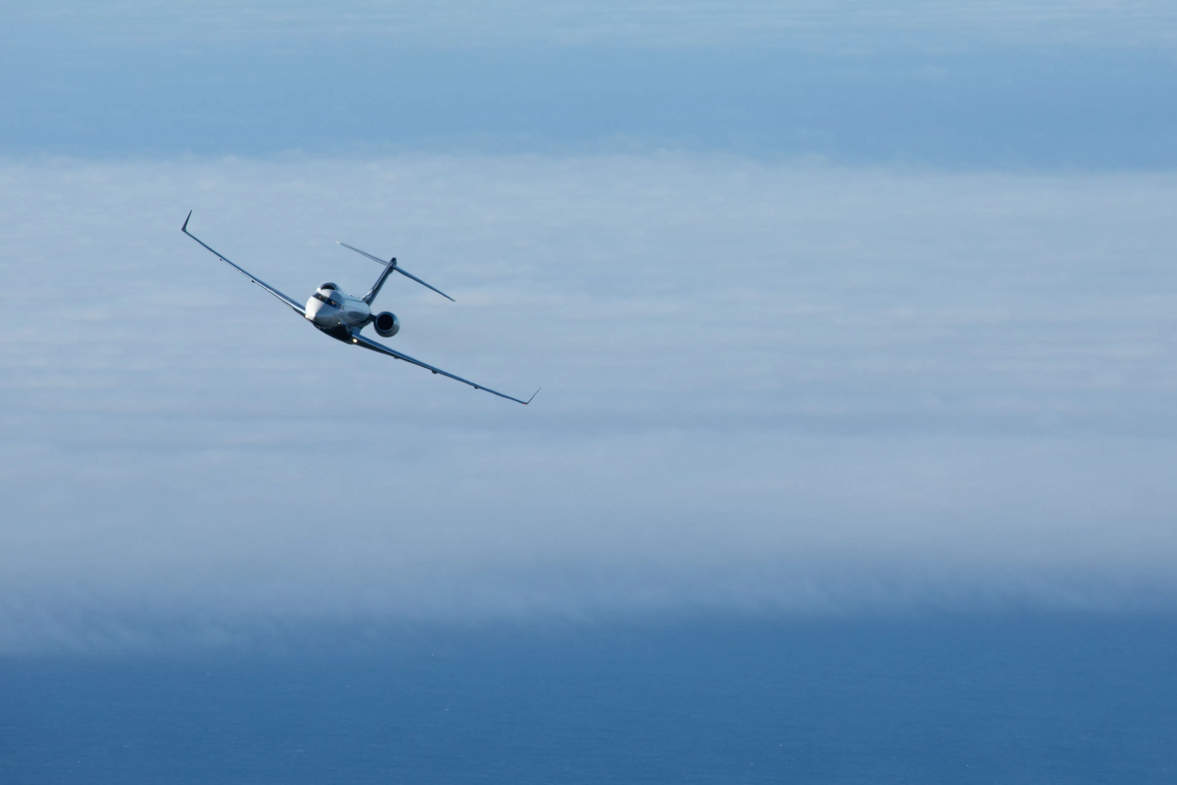 Private jet flying above the clouds