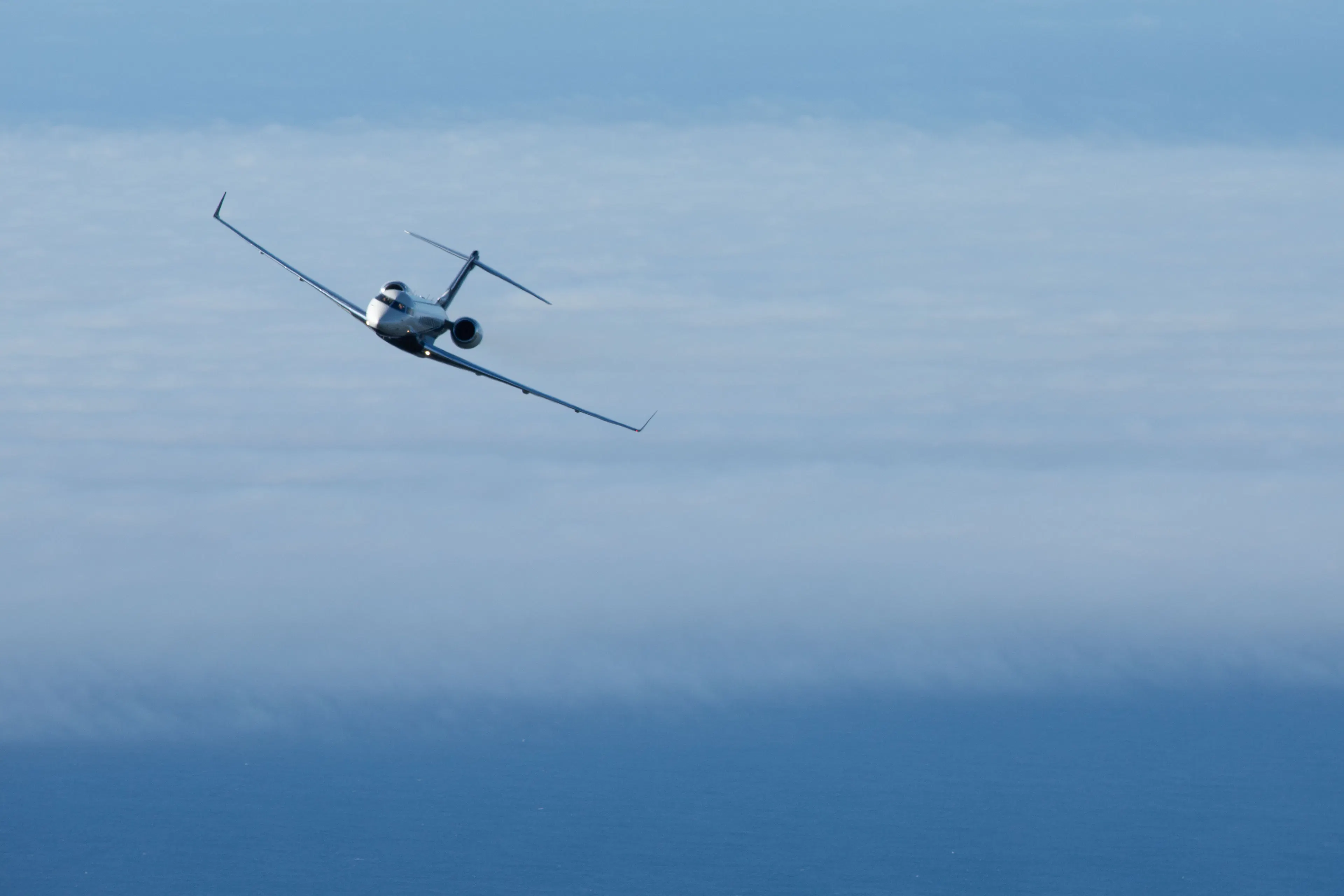 Private jet flying above the clouds