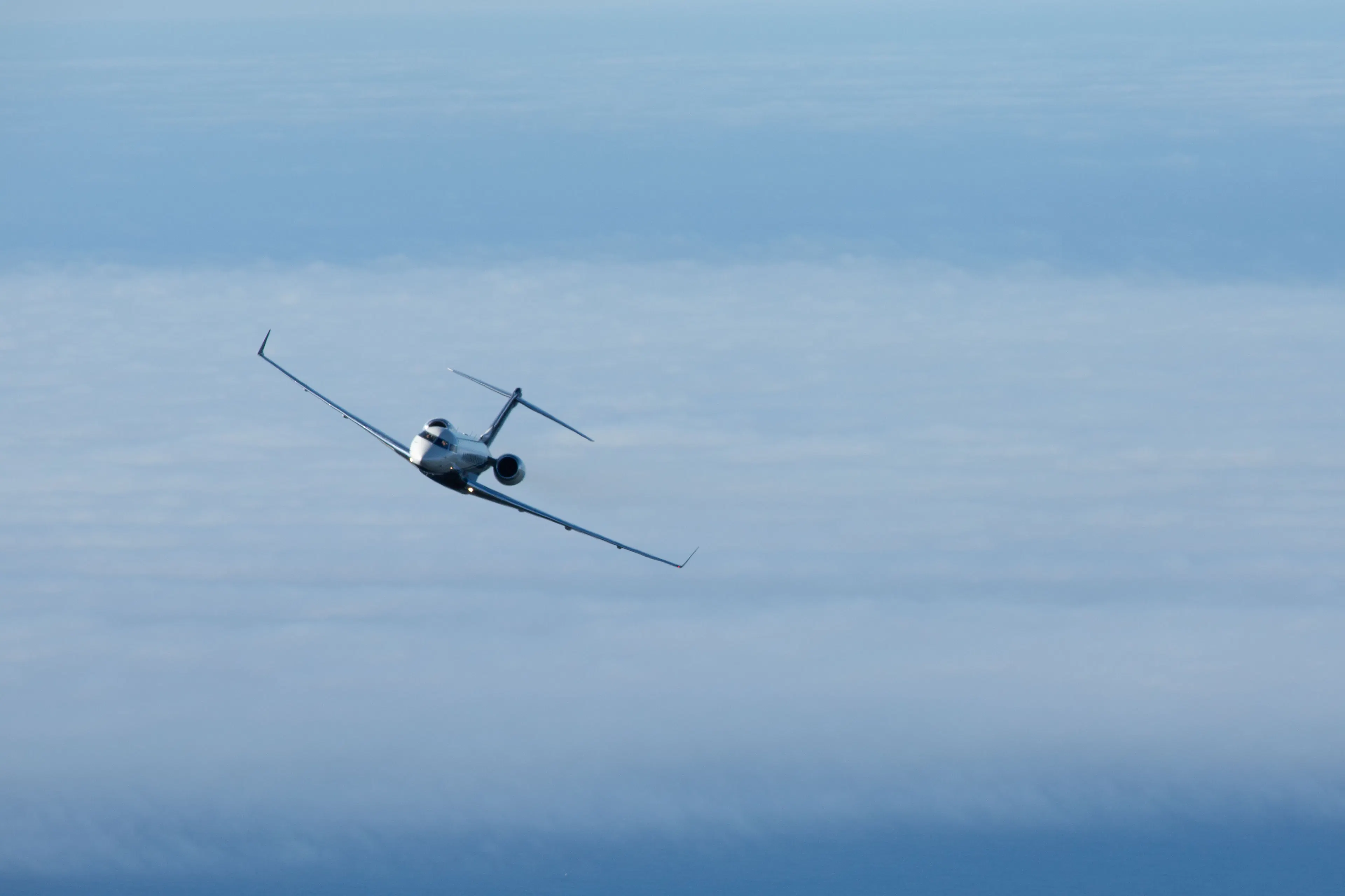 Private jet flying above the clouds