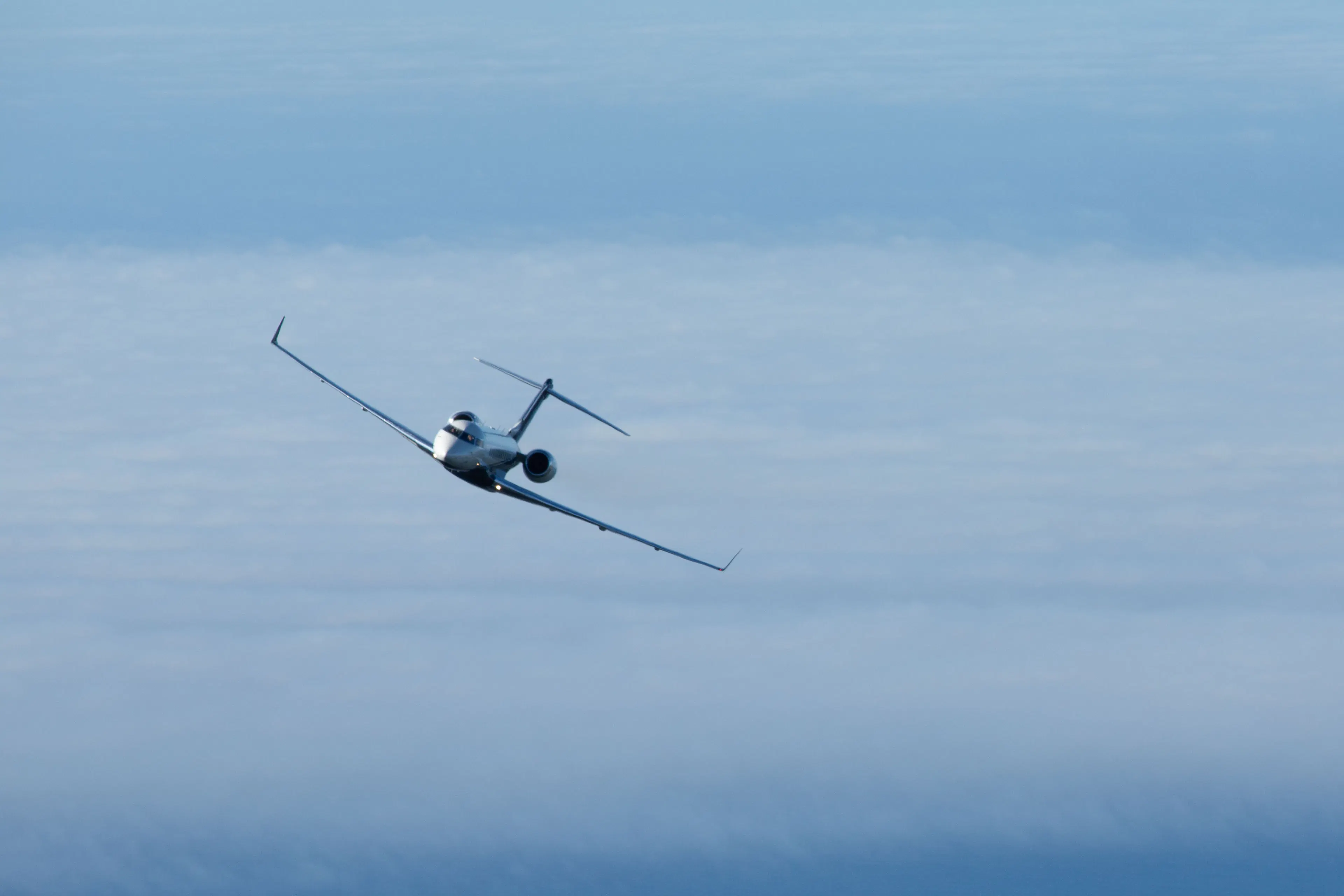 Private jet flying above the clouds