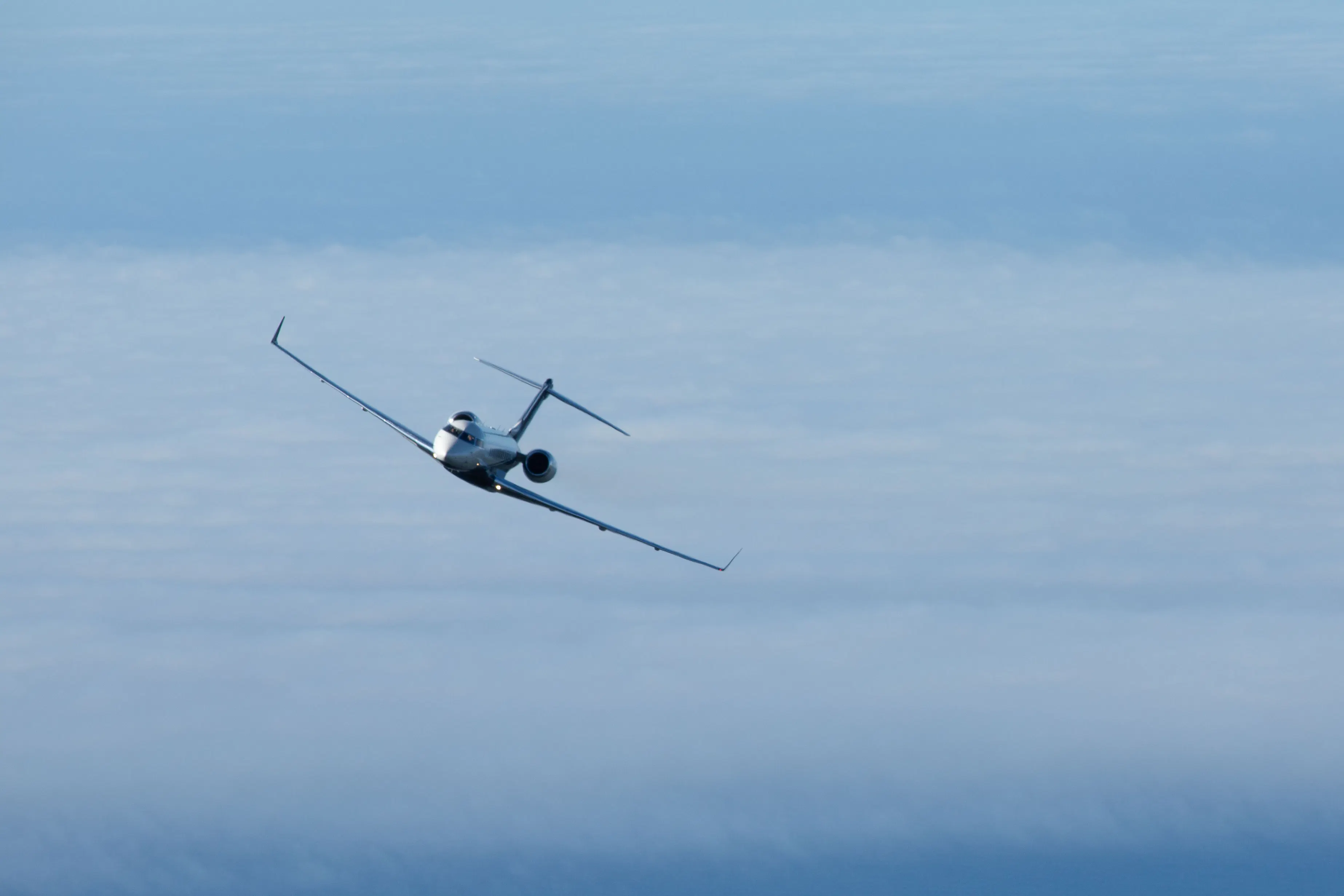 Private jet flying above the clouds