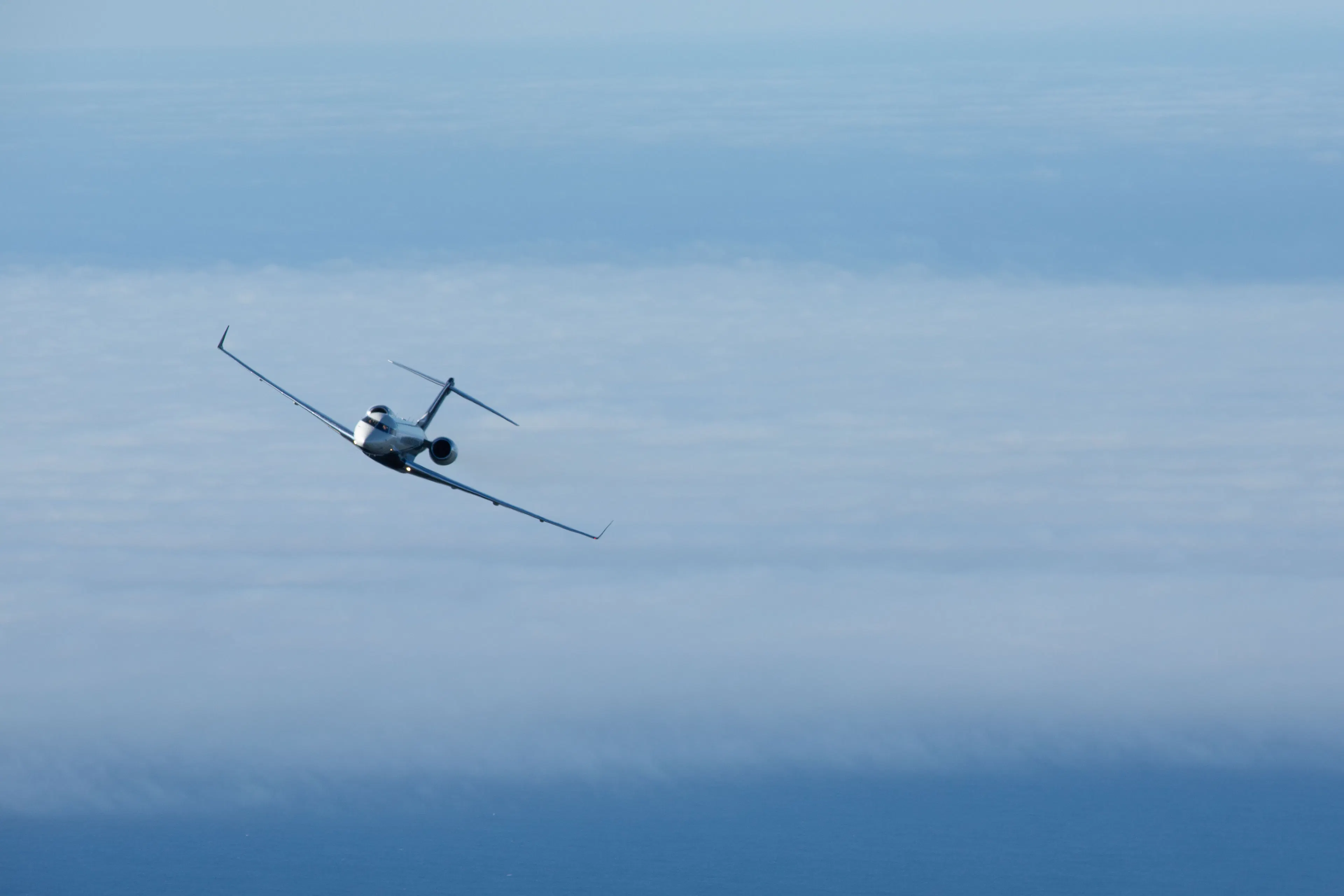 Private jet flying above the clouds