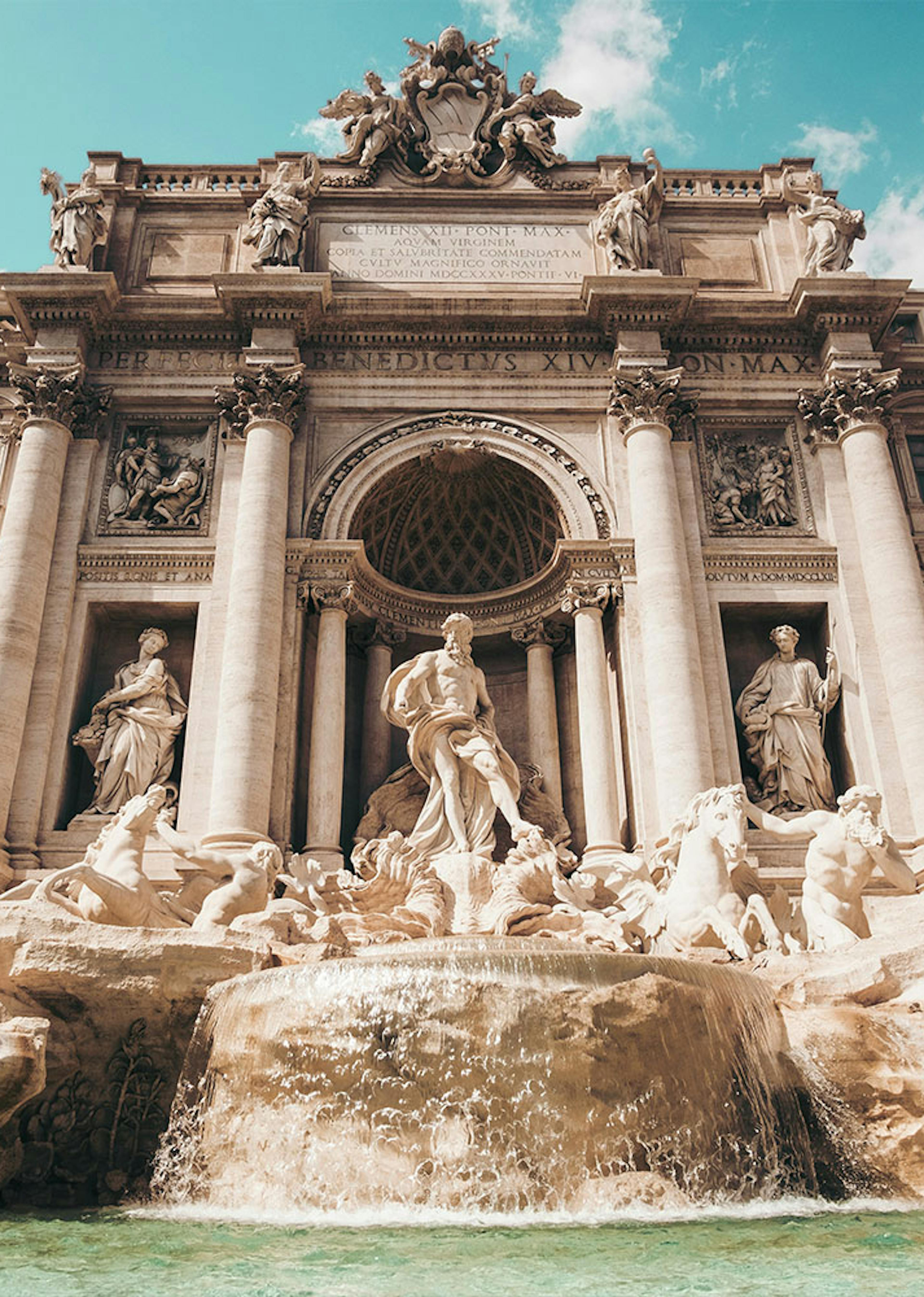 ornate statues adorn the lip of a fountain outside a beautiful building