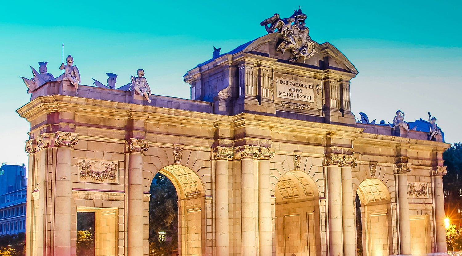 Arco illuminato da sotto che si staglia elegante nel cielo crepuscolare