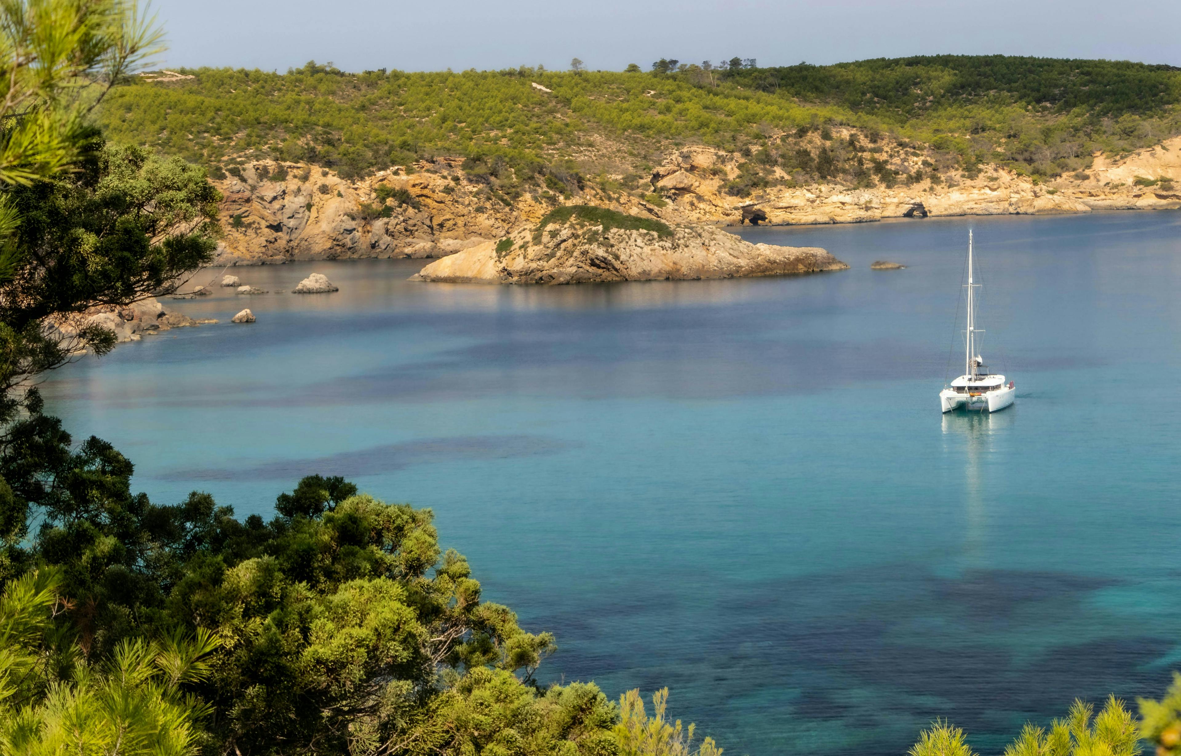 a lone boat sits on tranquil blue cove