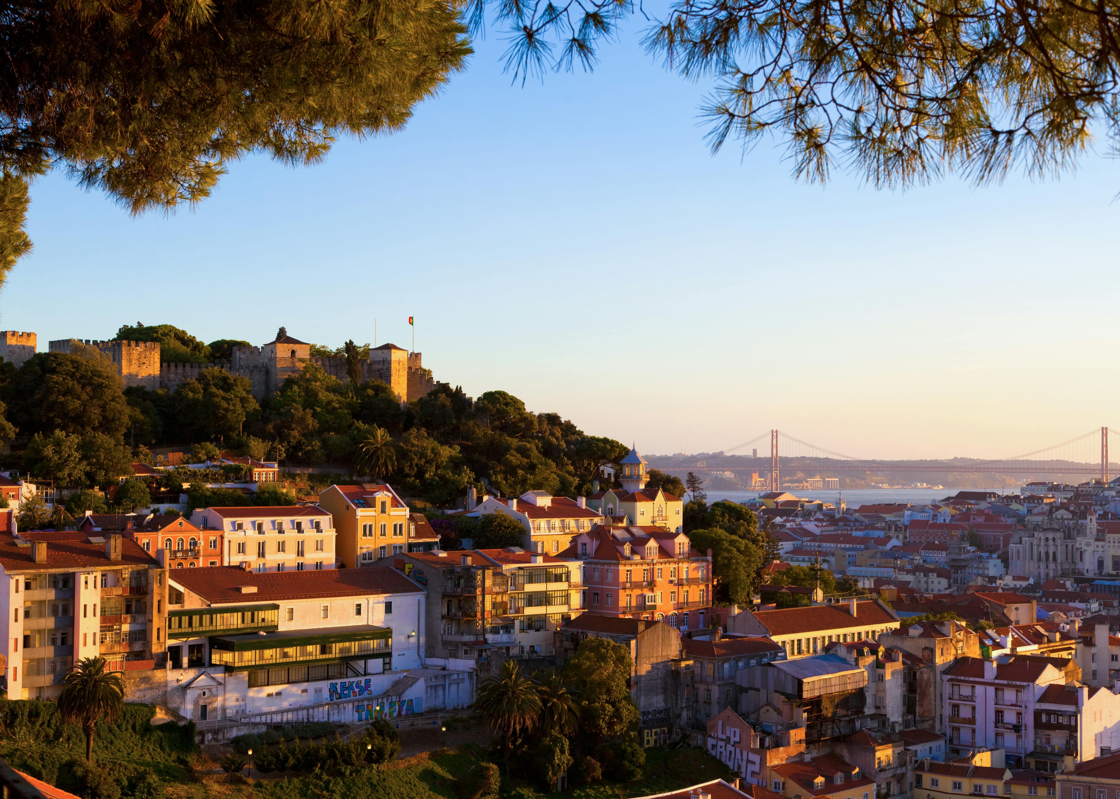 Buildings nestled on a hillside with a glow of a sunset