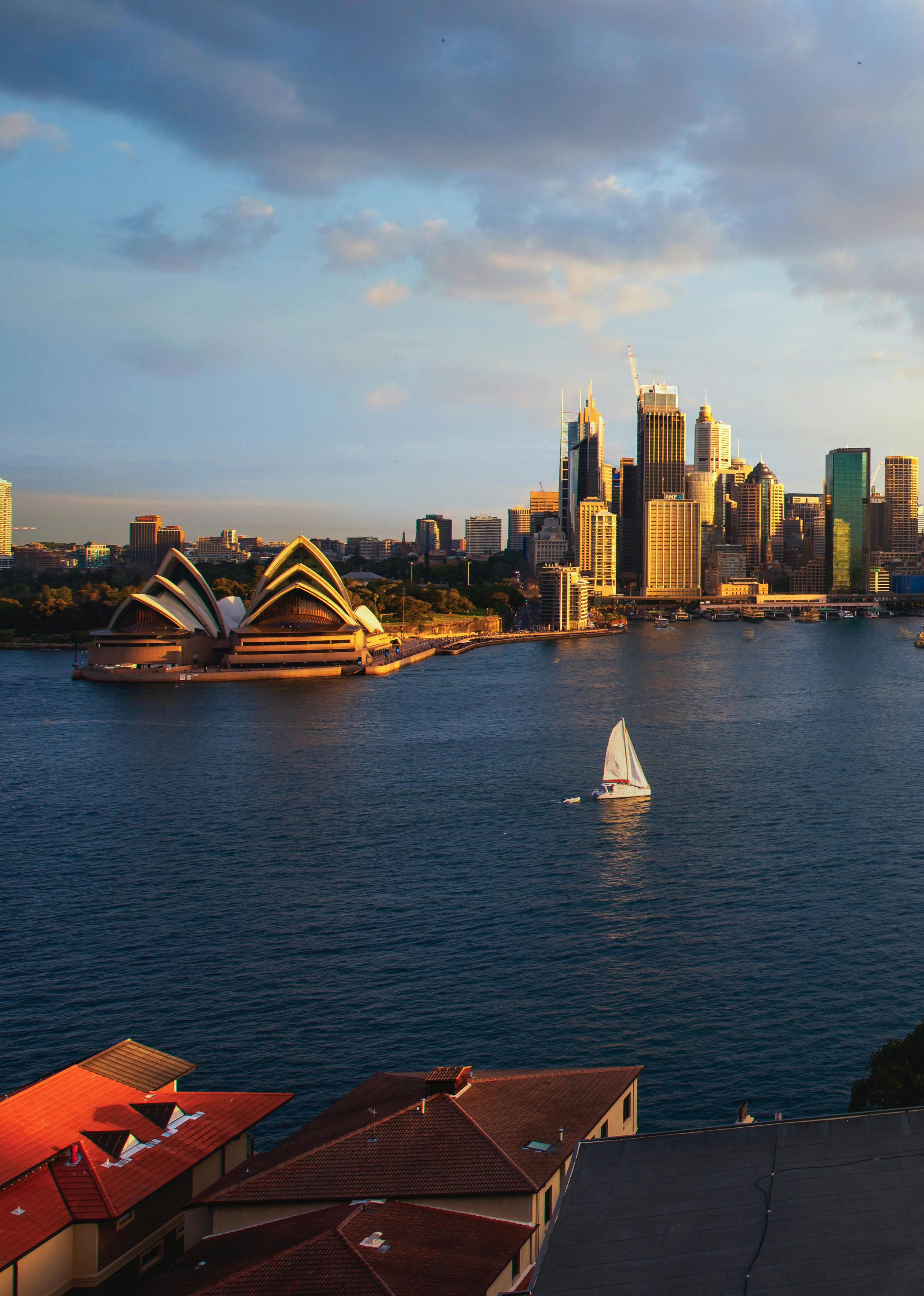 Bridge expanses over a body of water with a city skyline in the background