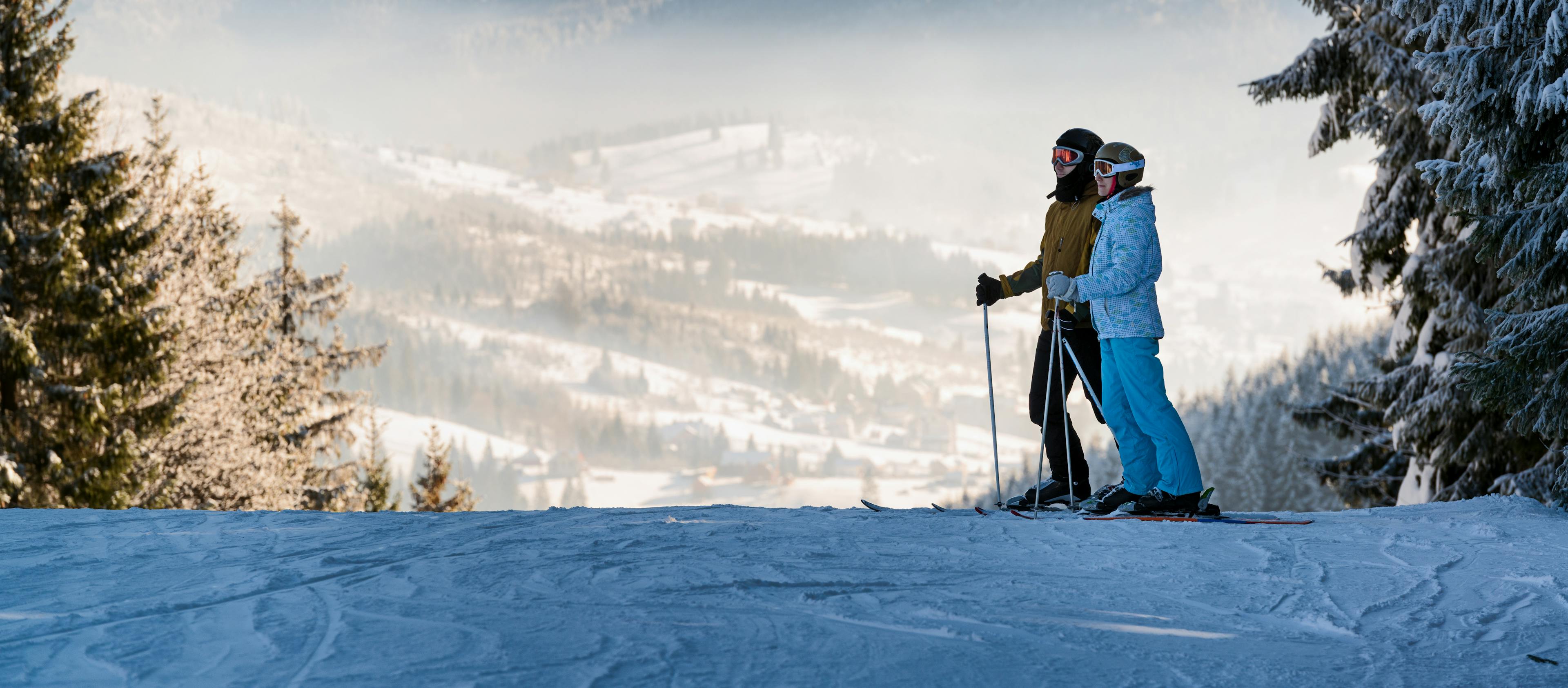 A couple of skiers take in the valley below