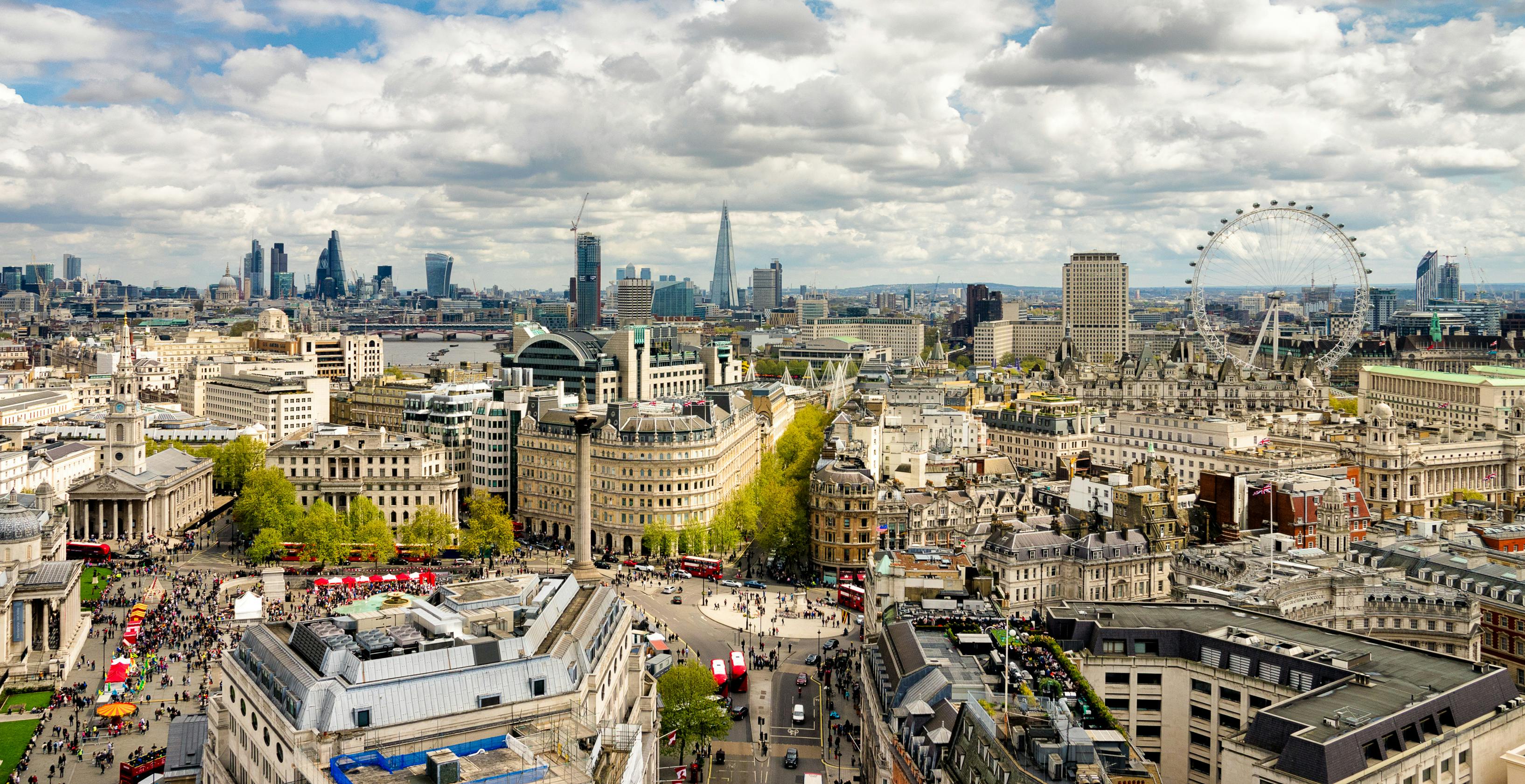 Skyline of United Kingdom city with ferris wheel and skyscrapers on the horizon