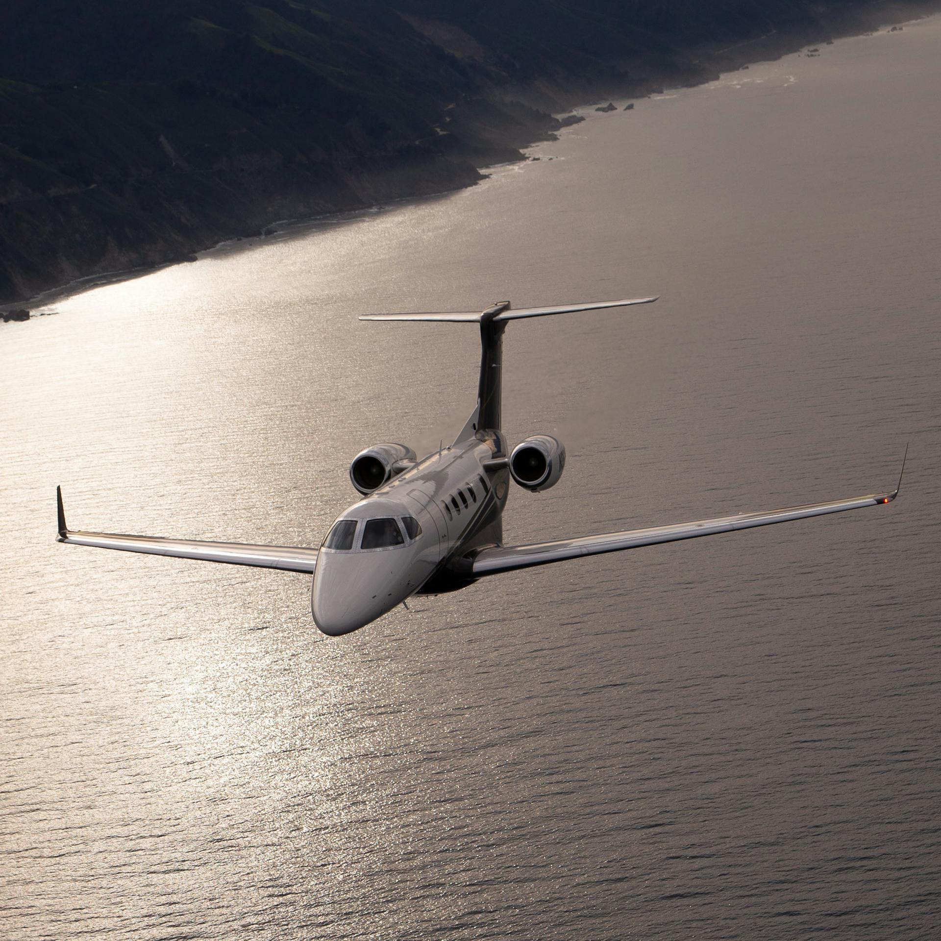 Phenom 300 soaring over calm waters