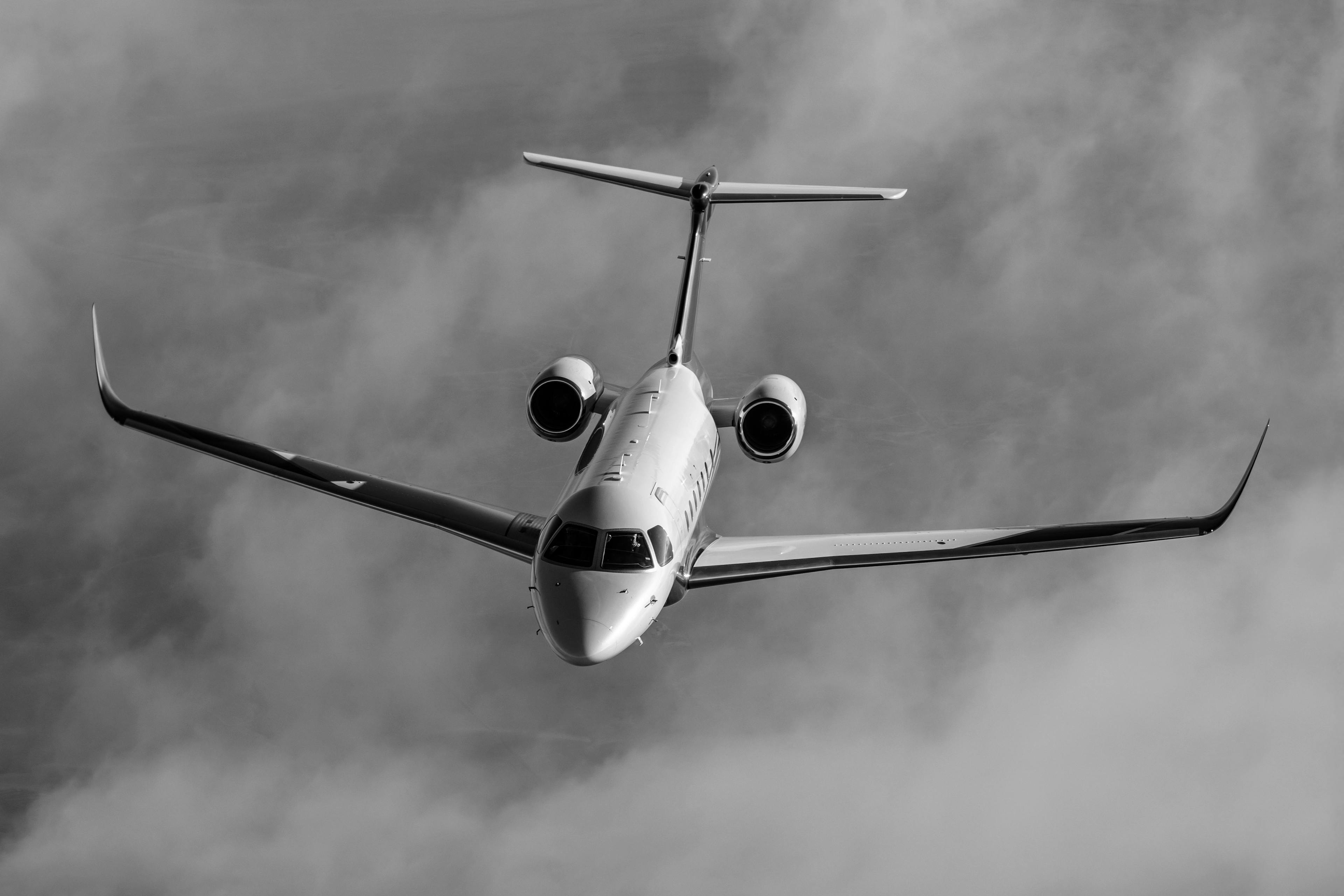 Praetor 600 flying over clouds in black and white