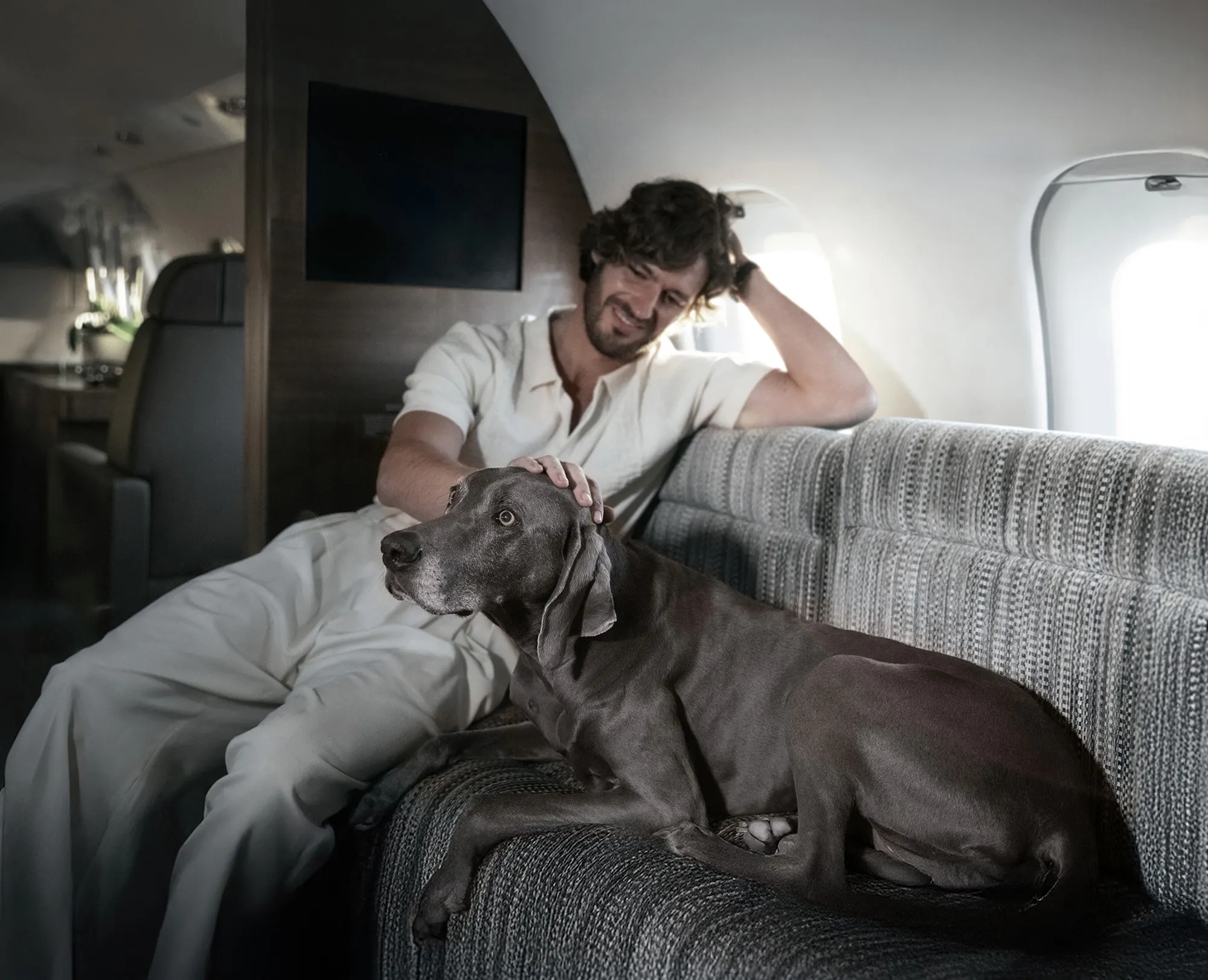 A man petting a dog on a private air