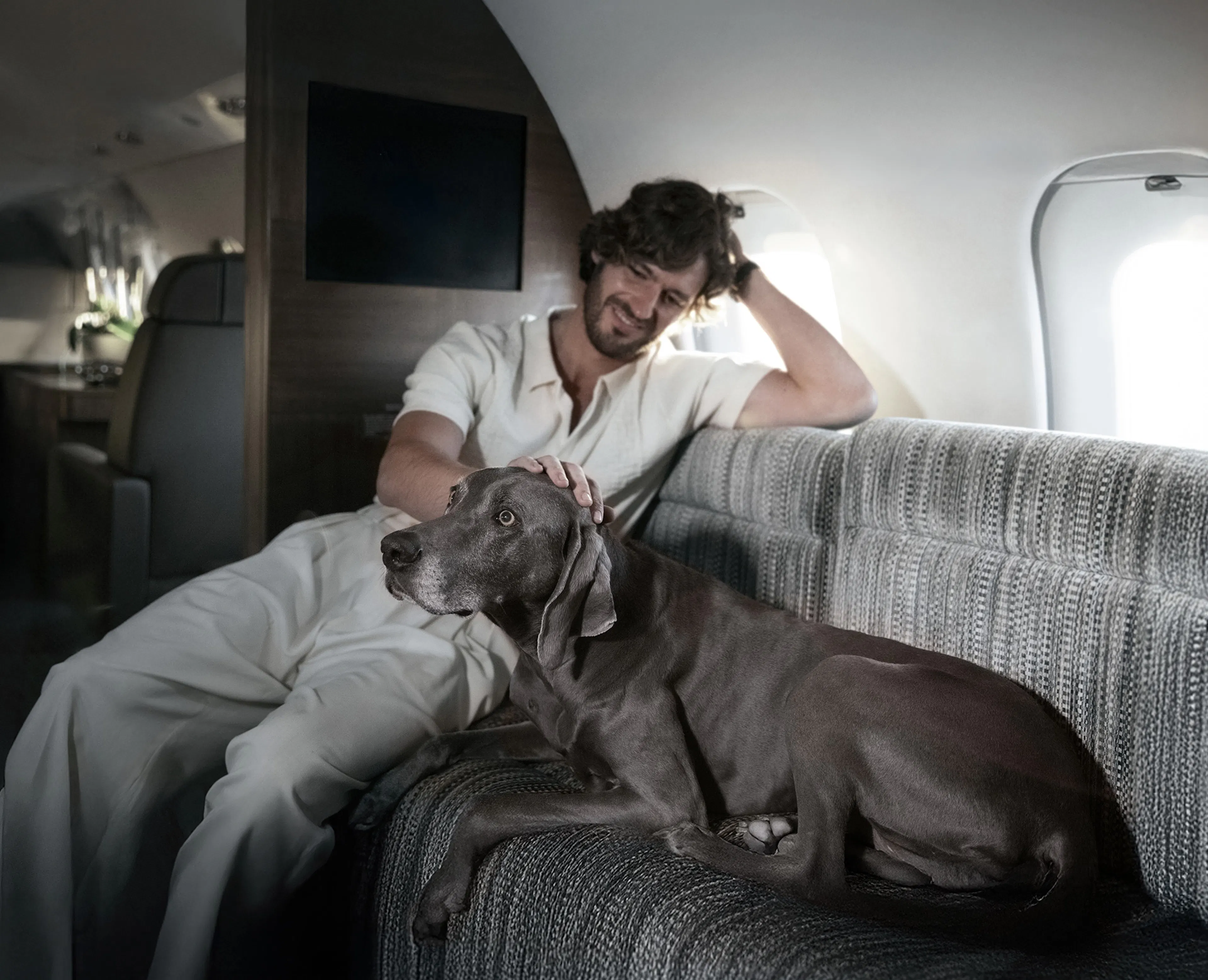 A man petting a dog on a private air
