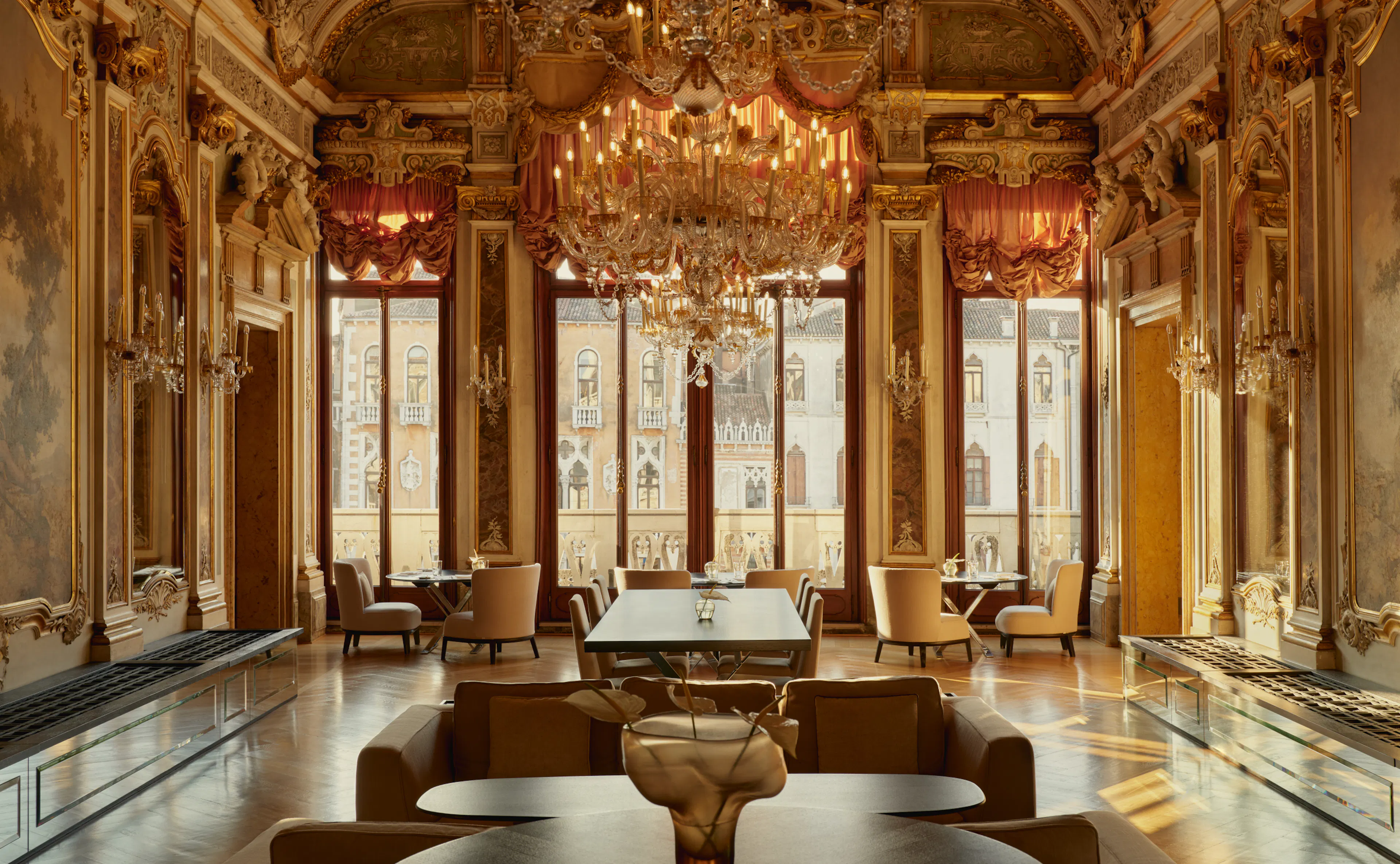 Elegant interior room with ornate gold detailing, columns, and seating area.