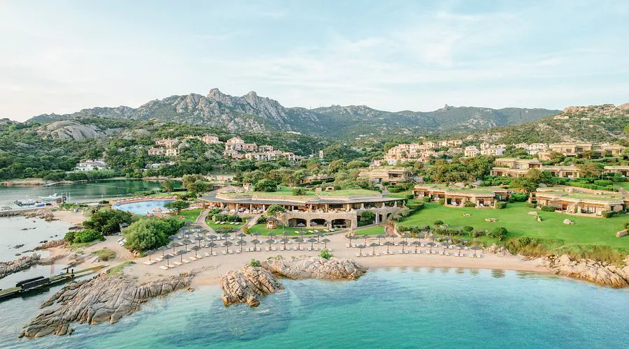 Coastal resort overlooking a sandy beach and turquoise bay.