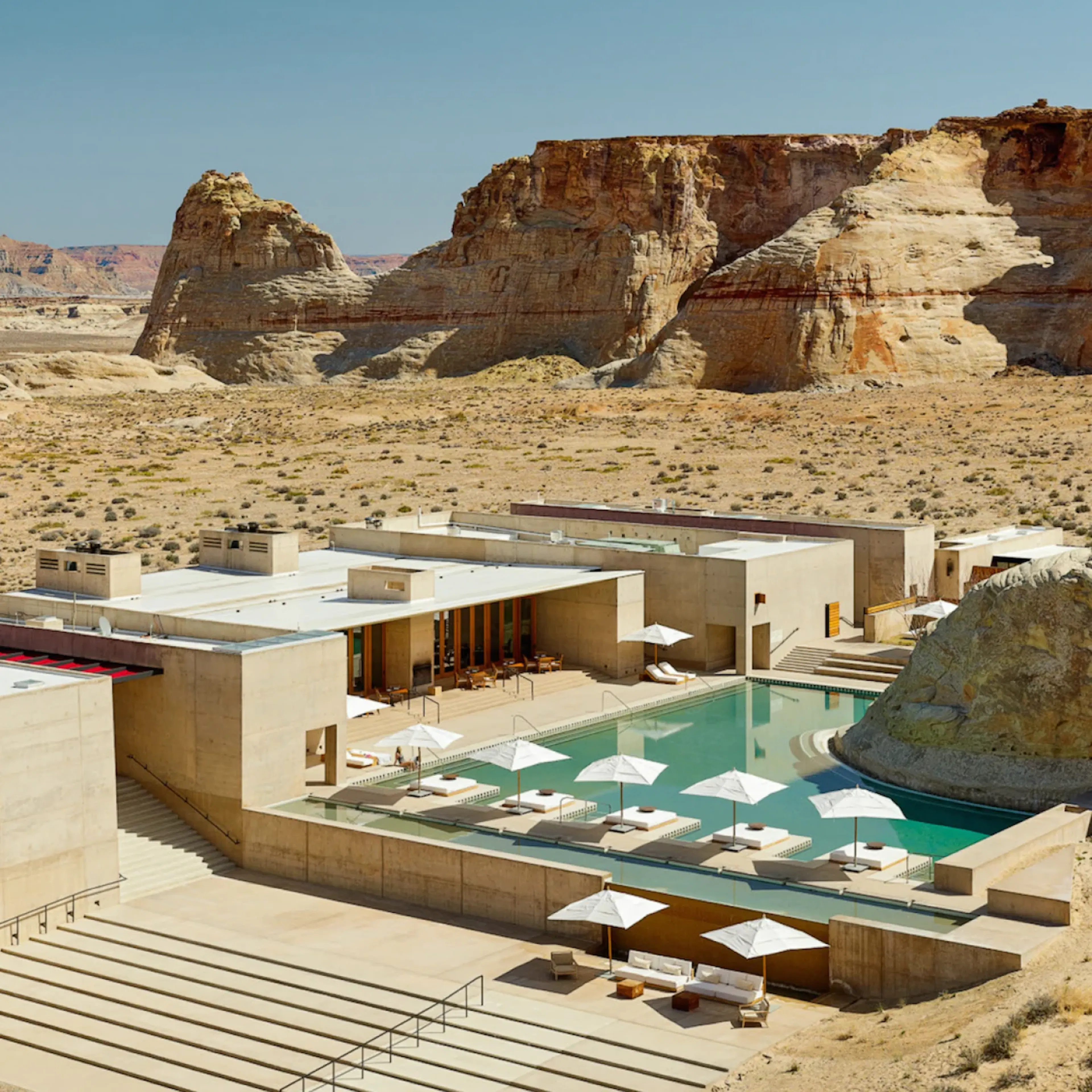 Luxury desert resort with private pool surrounded by sandstone cliffs.
