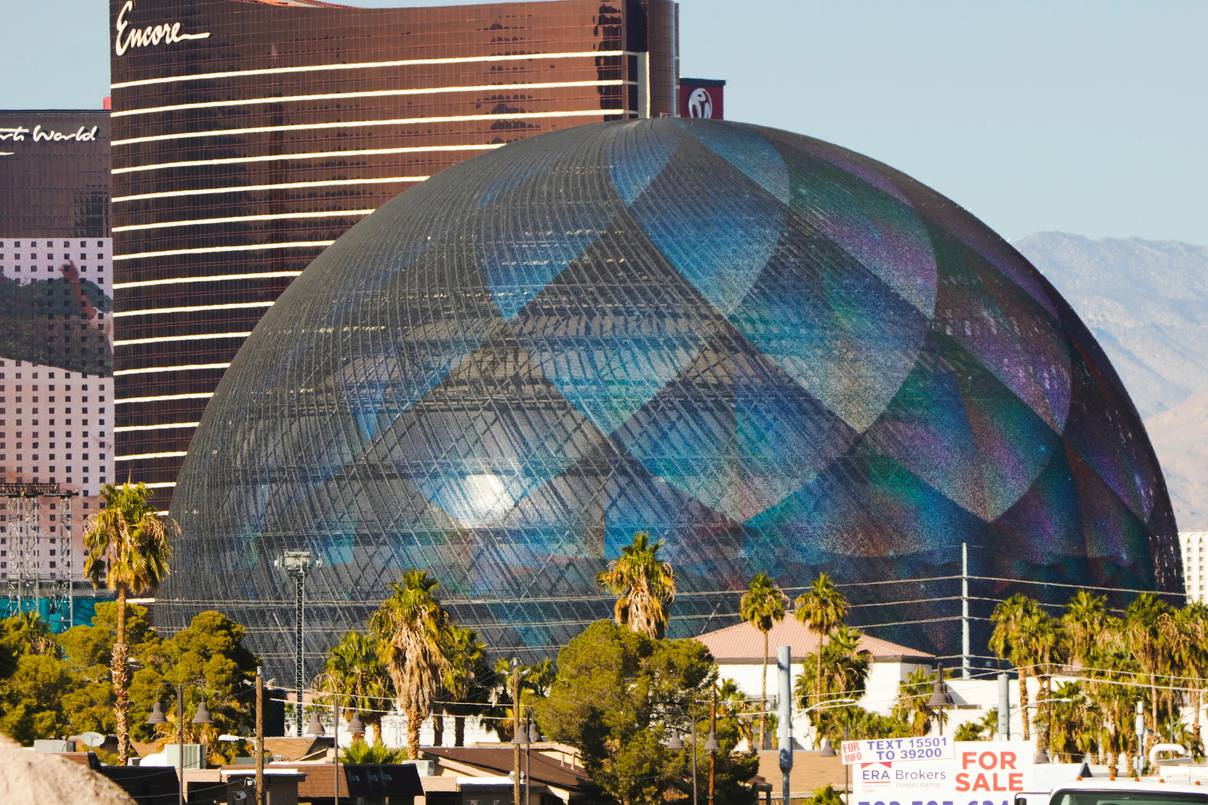 The Sphere in Las Vegas with a reflective exterior, palm trees, and resort buildings in the background.
