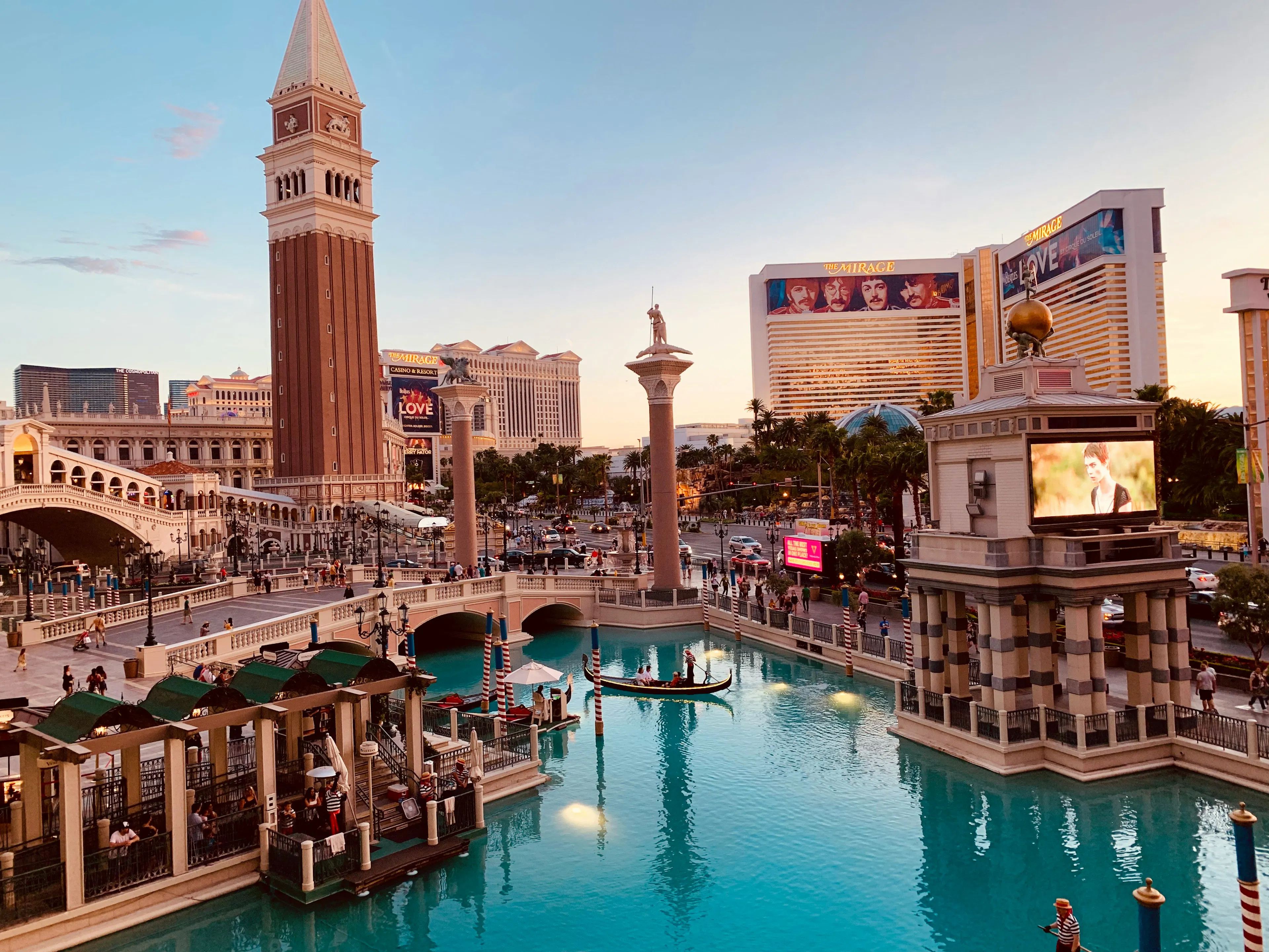 The Venetian Resort in Las Vegas with canal waterways, gondolas, arched bridges, and replica Venetian architecture at sunset.