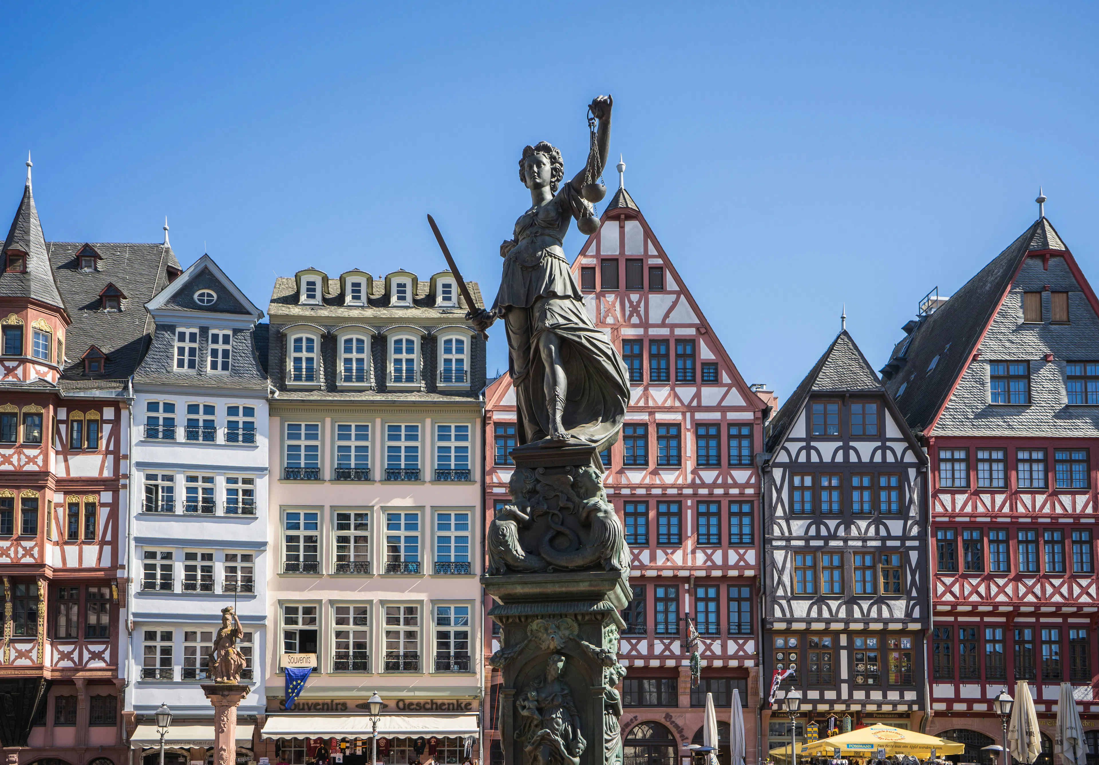 Justice statue in front of colorful historic buildings in Frankfurt’s Römerberg square.