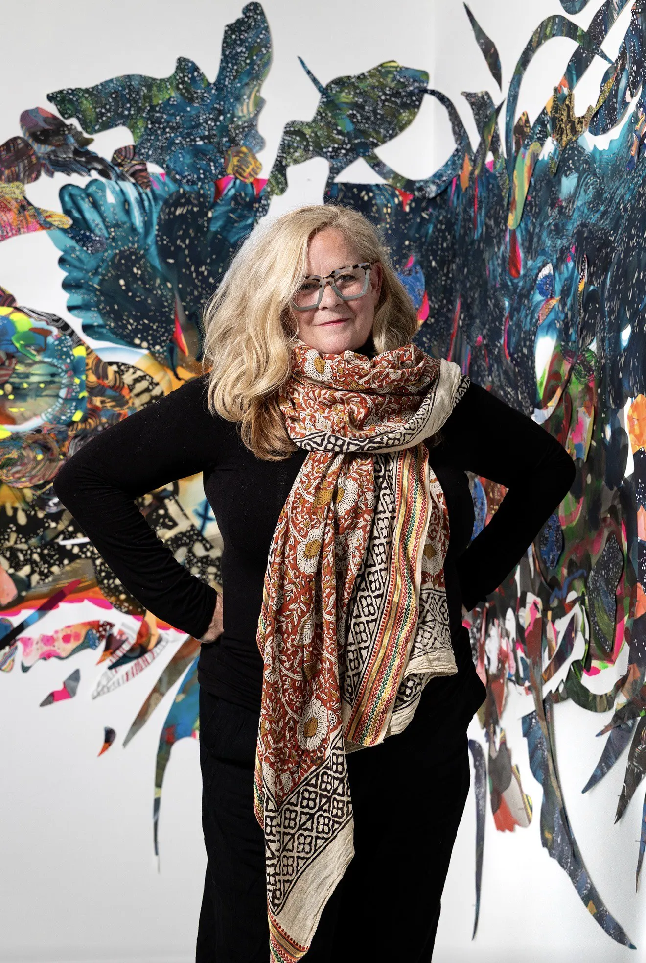 Contemporary artist Anne Austin Pearce in her studio with a large mixed-media wall installation.