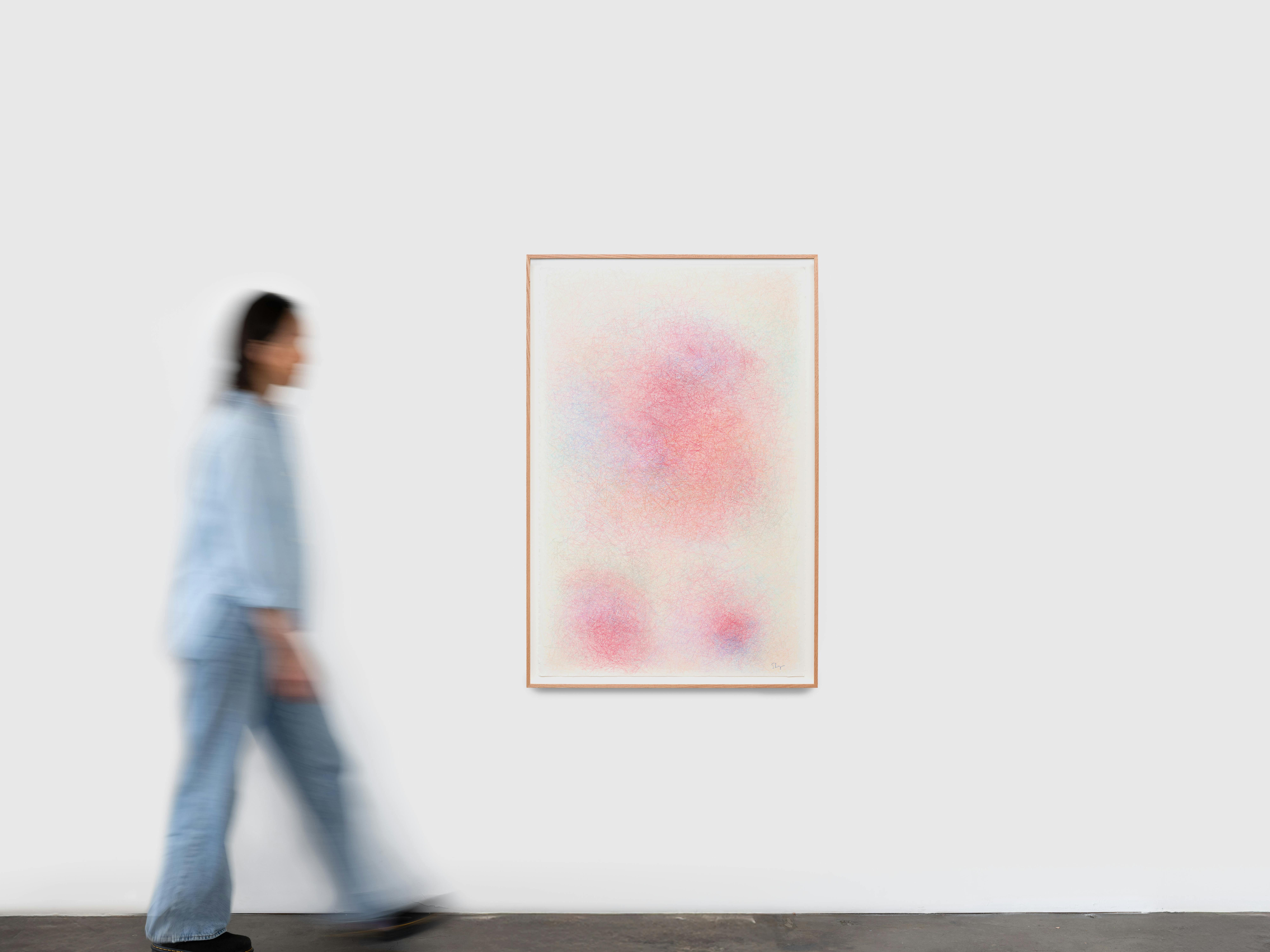 Framed abstract drawing installed on a white gallery wall, shown with a figure for scale.