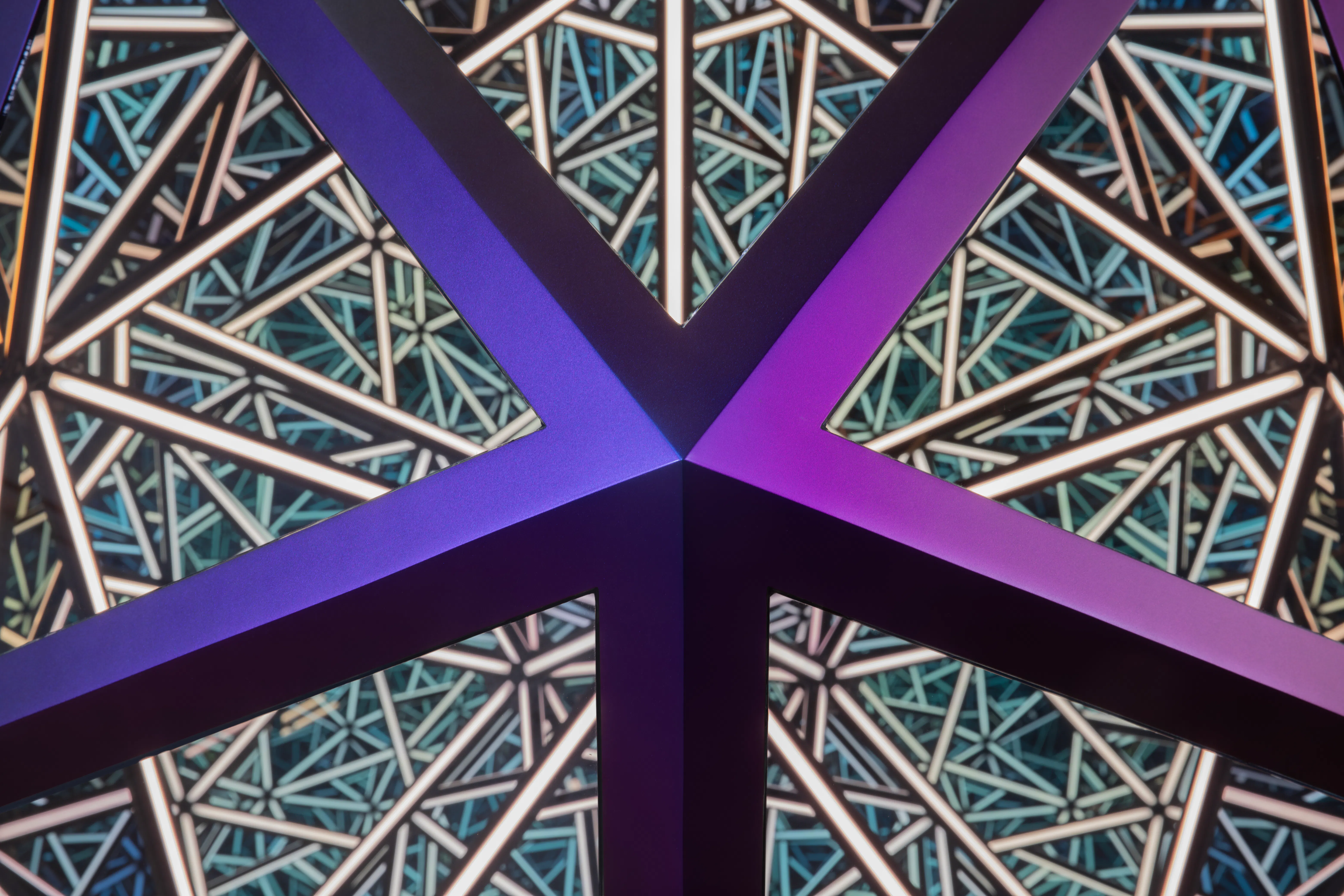 Detail view of an illuminated Icosahedron sculpture by Anthony James, showing intersecting geometric structures and light elements.