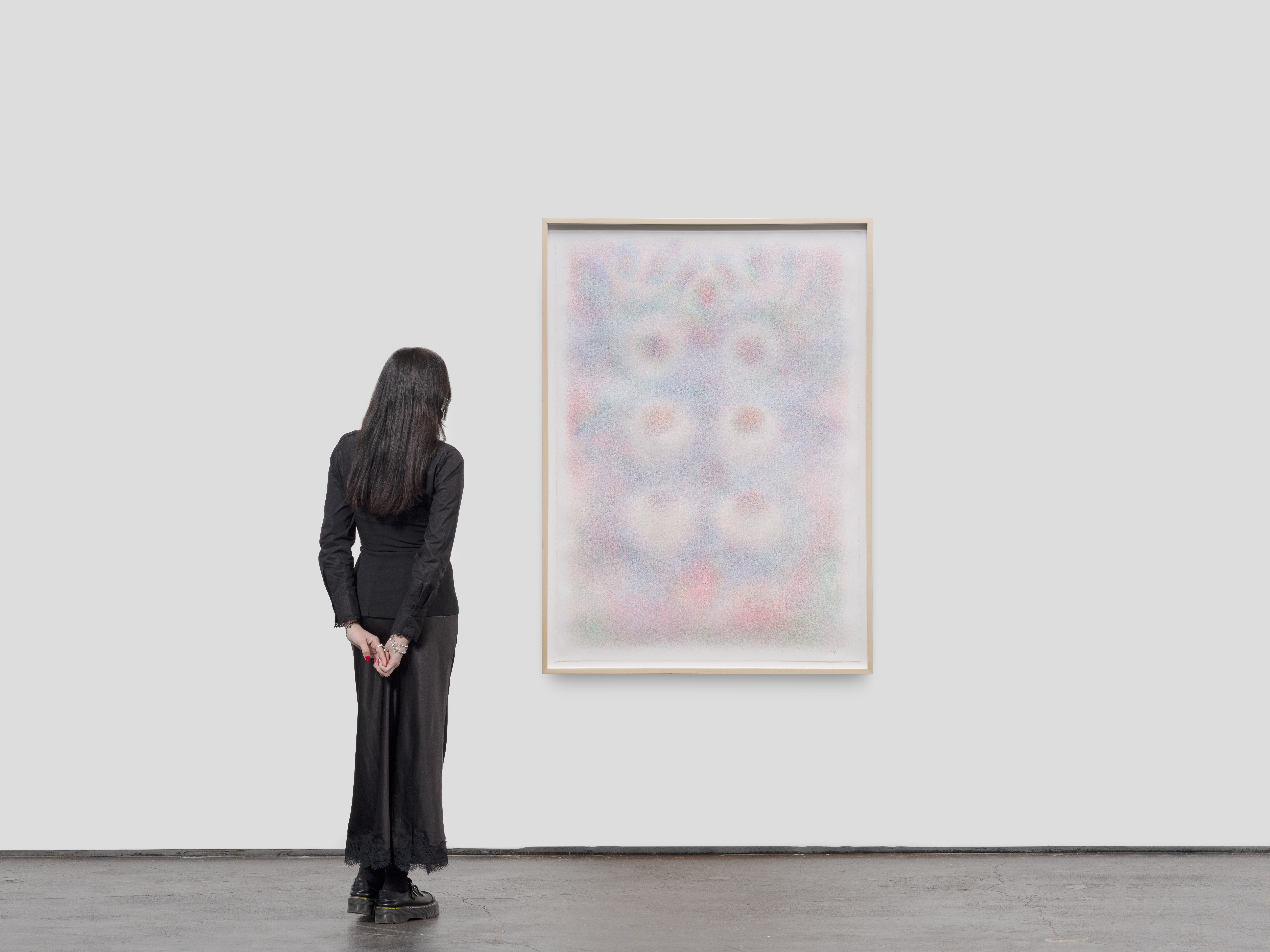 Installation view of Blue, Iris by Sheng Lor from the exhibition Interstitial at Gallery Sonder, showing the framed work on a white wall with a viewer standing nearby for scale.