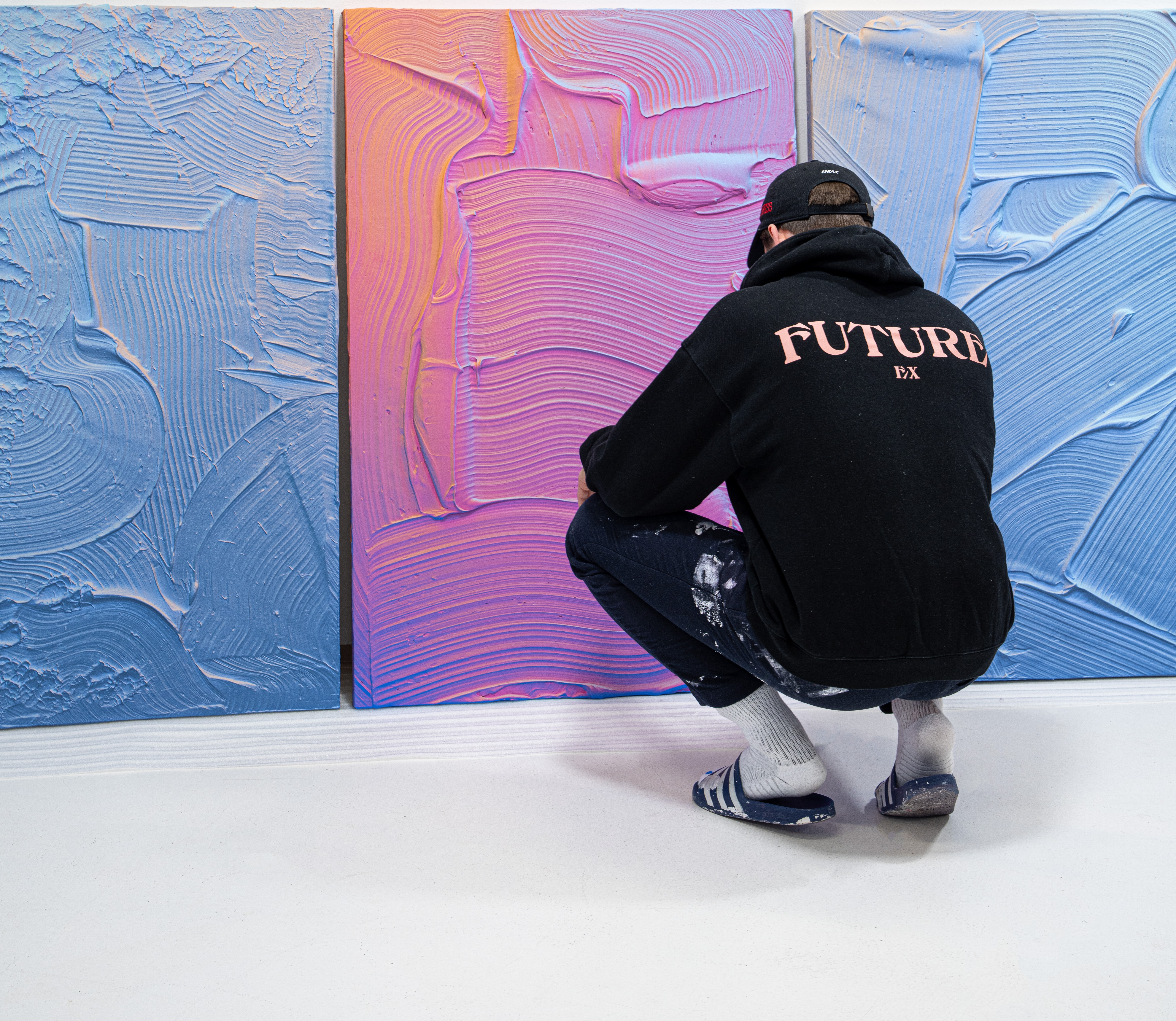 Ruben Benjamin in his studio inspecting textured paintings before shipping for his inaugural U.S. exhibition After the Dust Settles with Gallery Sonder.