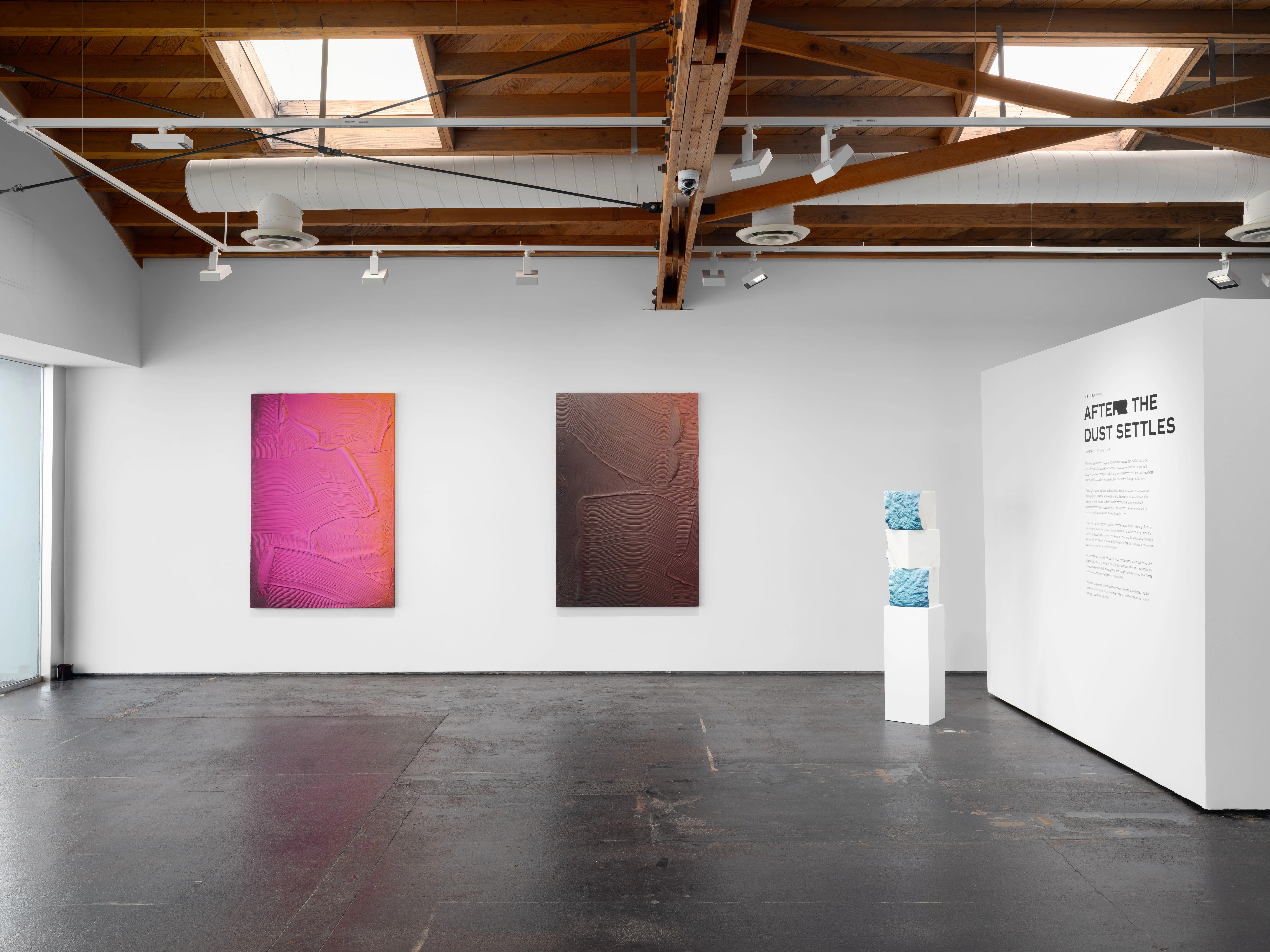 Ruben Benjamin, After The Dust Settles, 2026 — wide installation view at Gallery Sonder showing two large-scale paintings on a white wall alongside a pedestal-mounted sculpture, with the exhibition title wall text visible, emphasizing spatial layout, scale, and architectural context. Gallery Sonder, Orange County