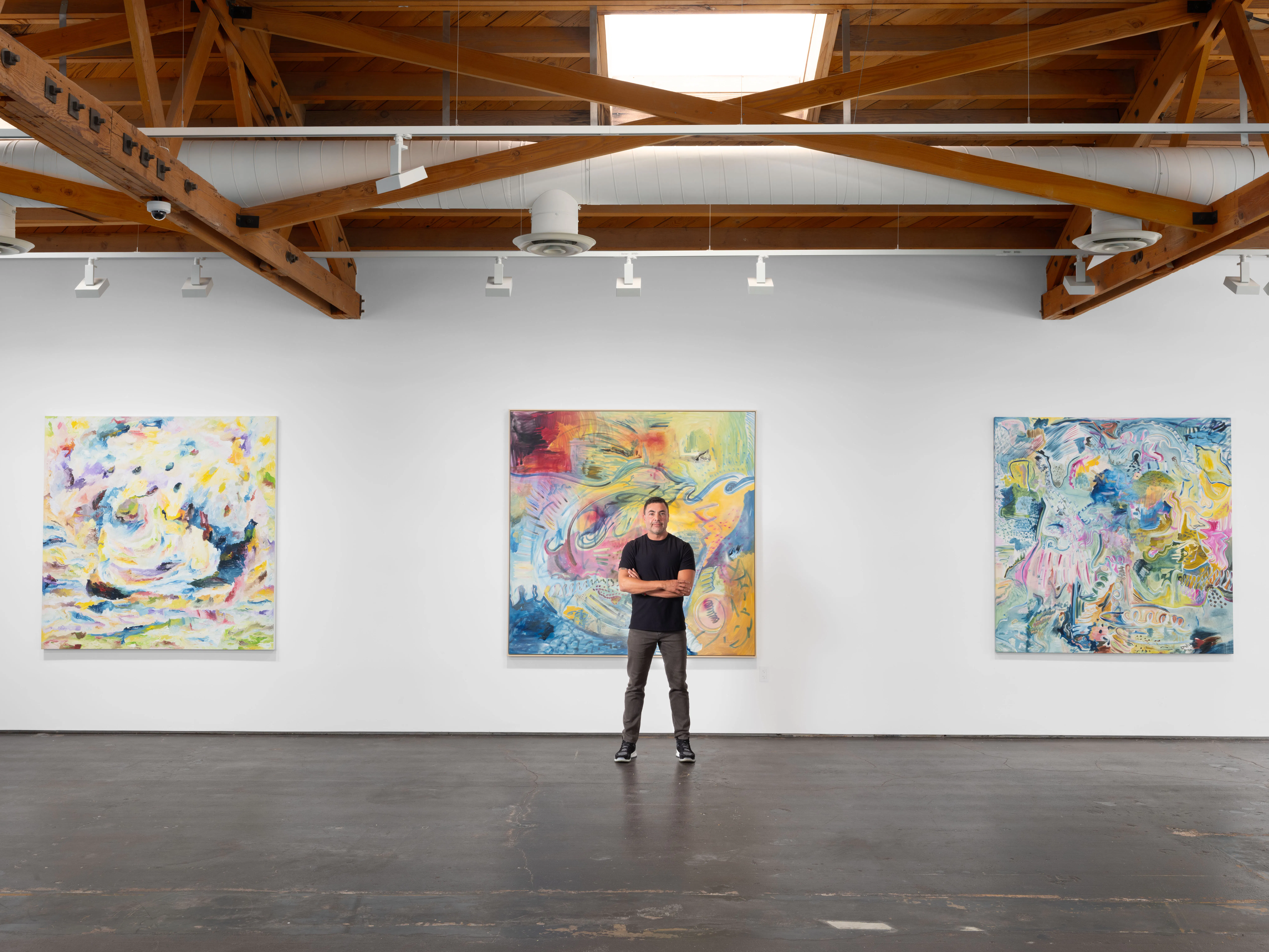 Portrait installation view of artist Moncho inside his solo exhibition Awakening at Gallery Sonder, surrounded by large-scale contemporary abstract paintings exploring gesture, color, and layered abstraction.