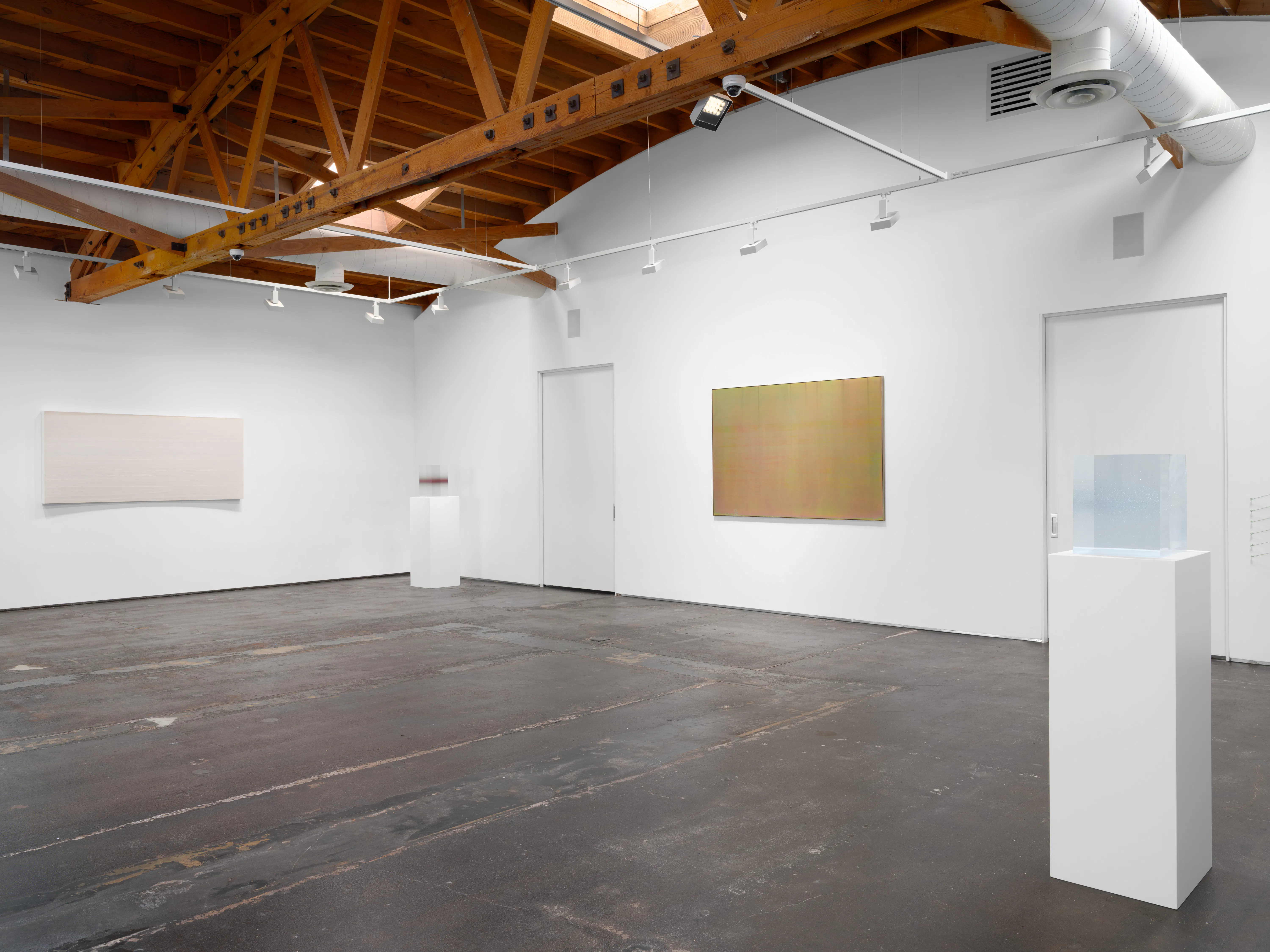 Installation view of Keeping Things Whole showing a gallery wall with a translucent blue sculpture on a pedestal and abstract wall works.