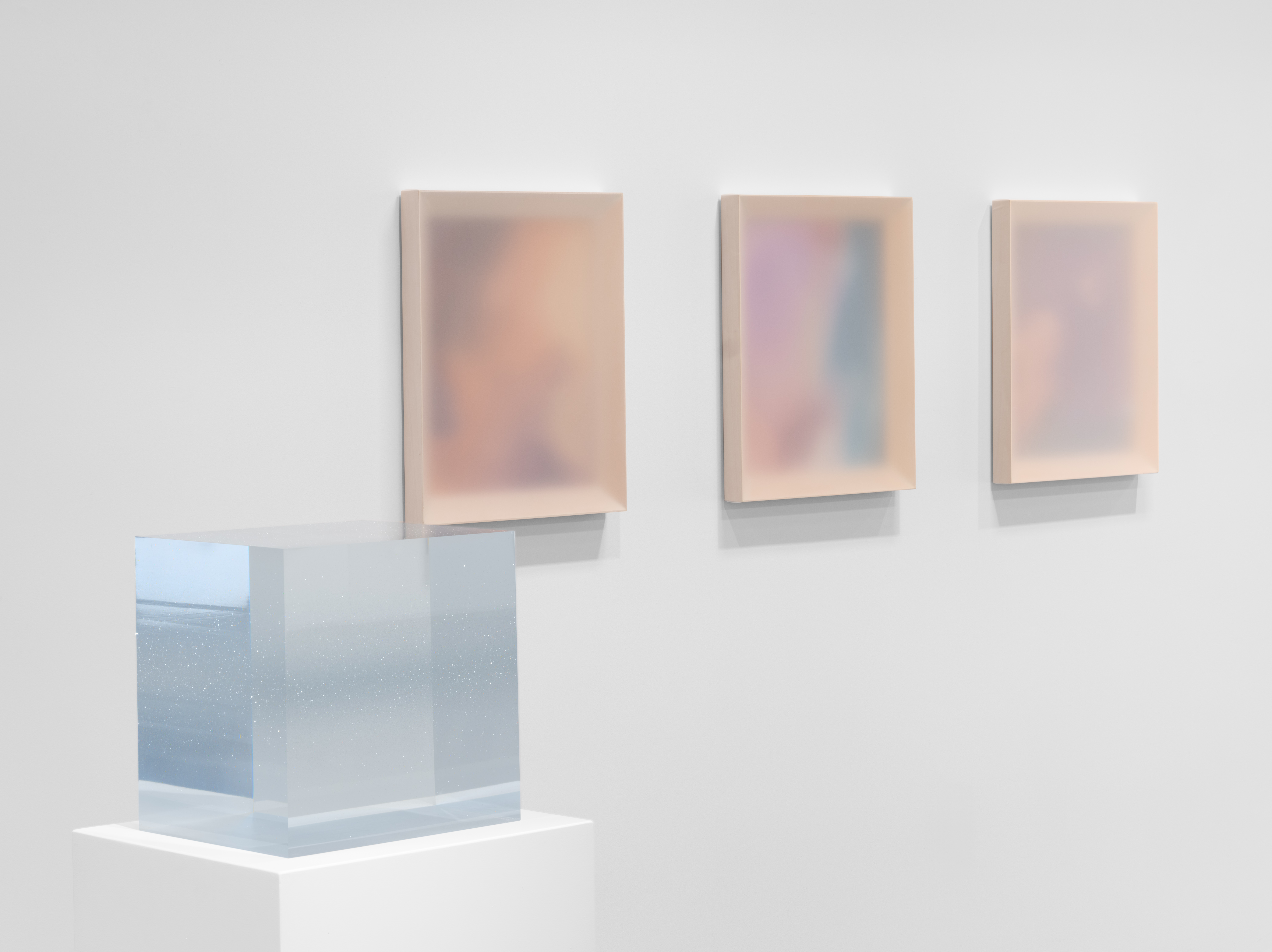 Installation view of Keeping Things Whole at Gallery Sonder, with a translucent cube sculpture in the foreground and softly colored wall works behind it.