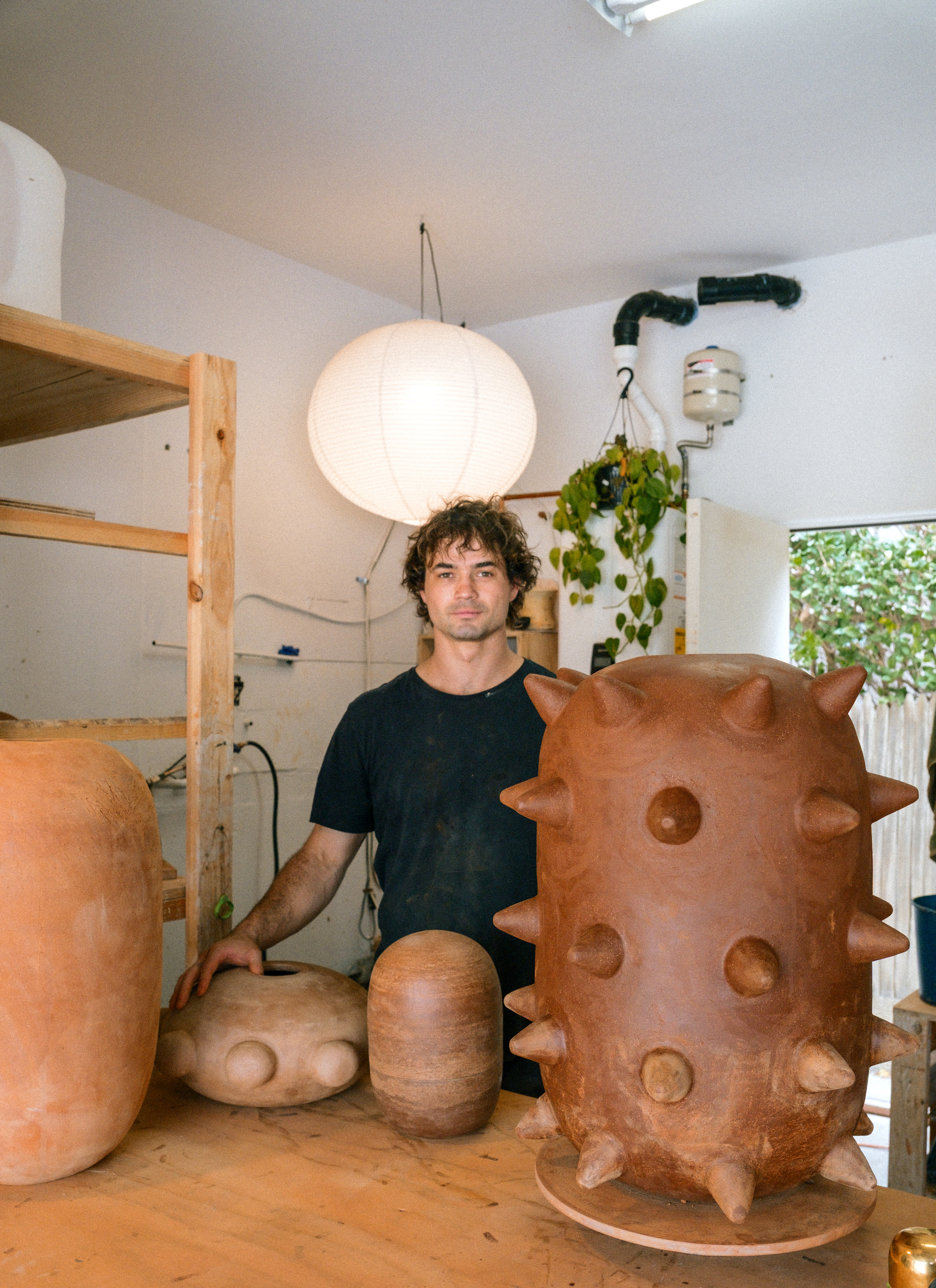 Contemporary artist Theo Hirschfield in his ceramics studio with hand-built clay sculptures.