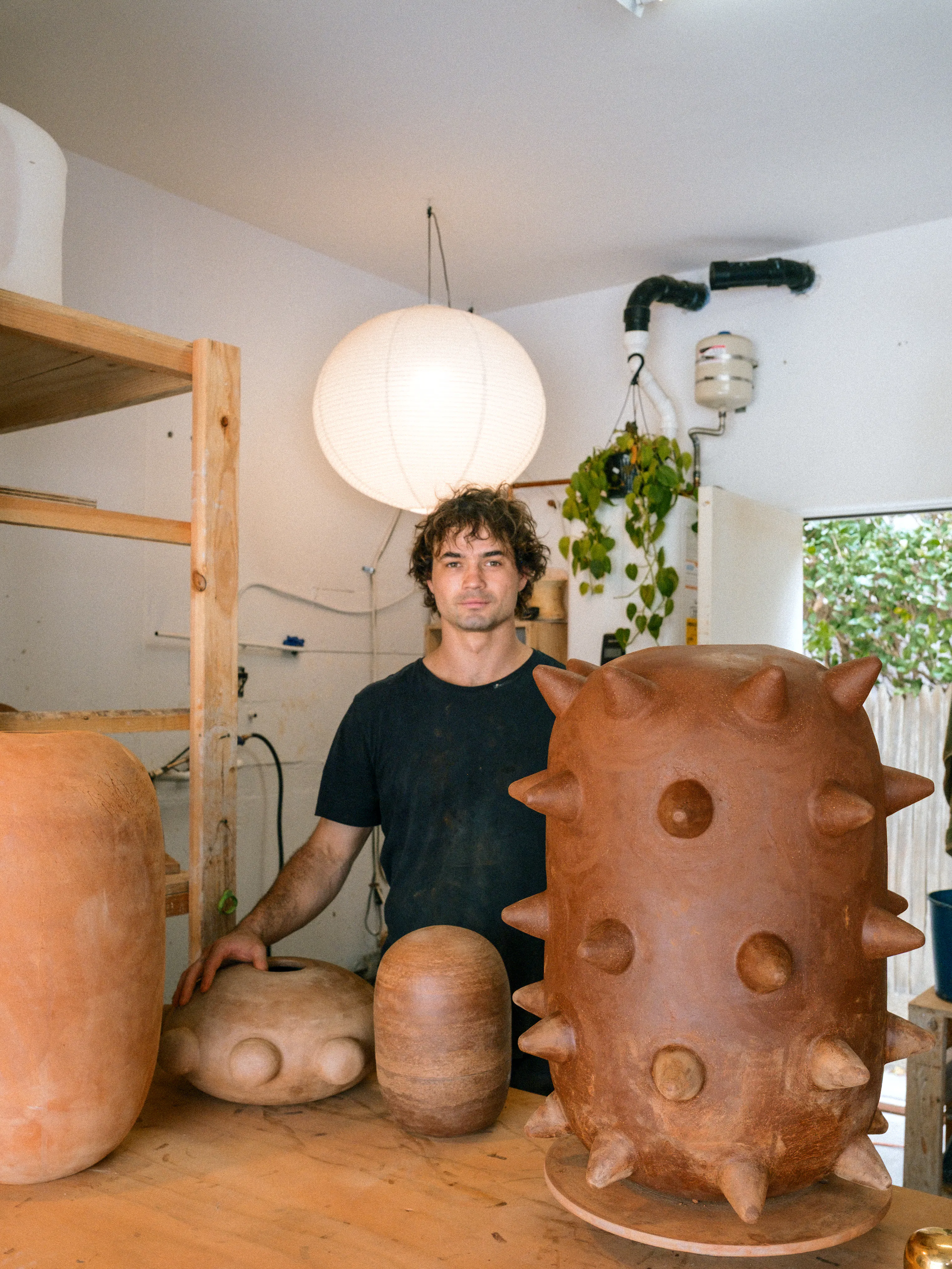 Contemporary artist Theo Hirschfield in his ceramics studio with hand-built clay sculptures.