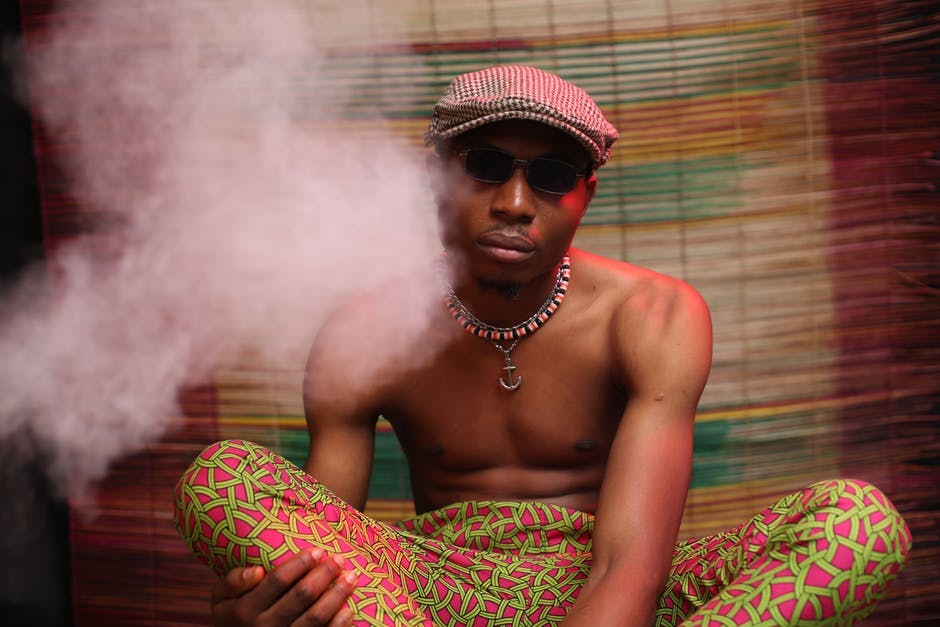 man sitting cross-legged with smoke around him 