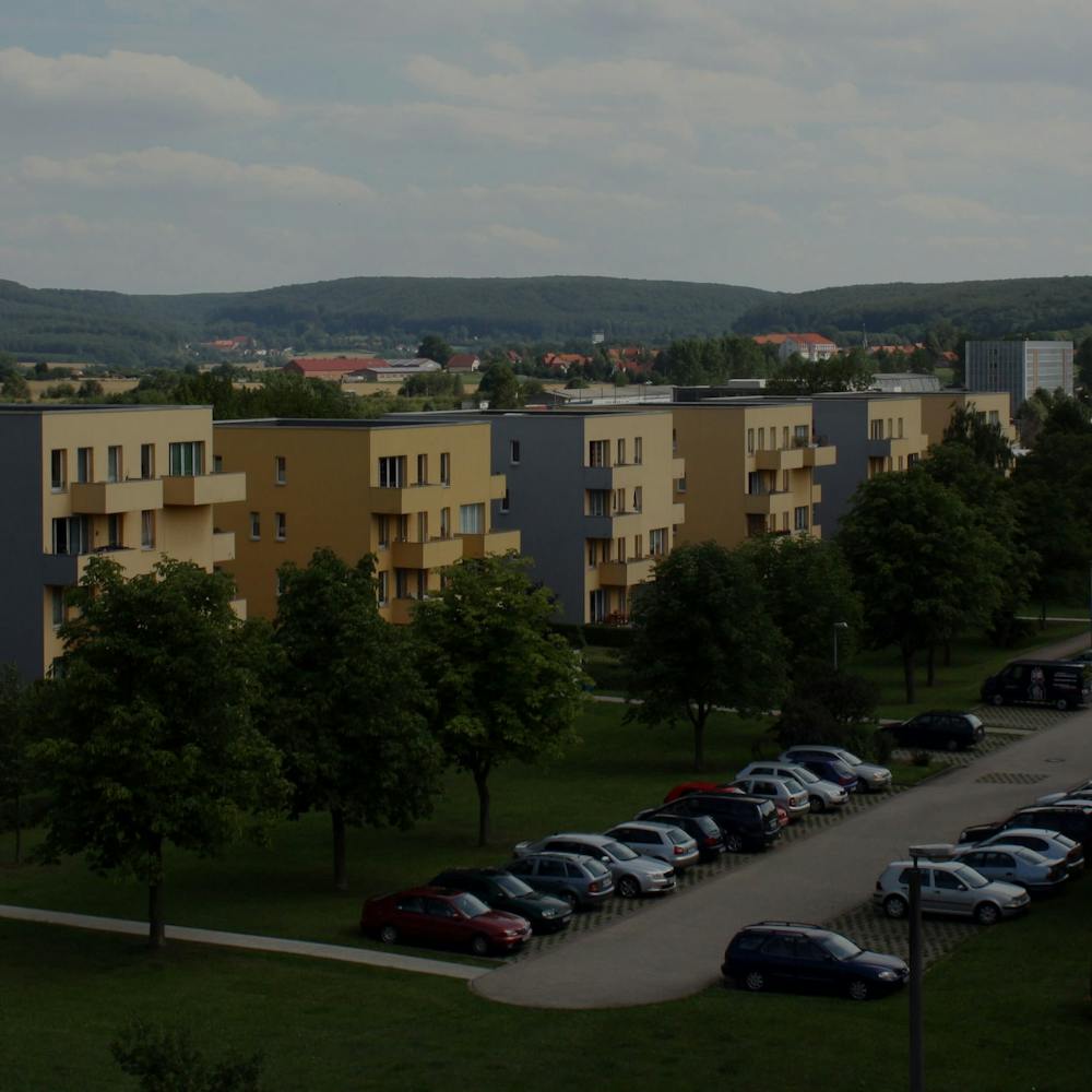 blocuri rezidentiale galbene in peisaj cu plante si gazon