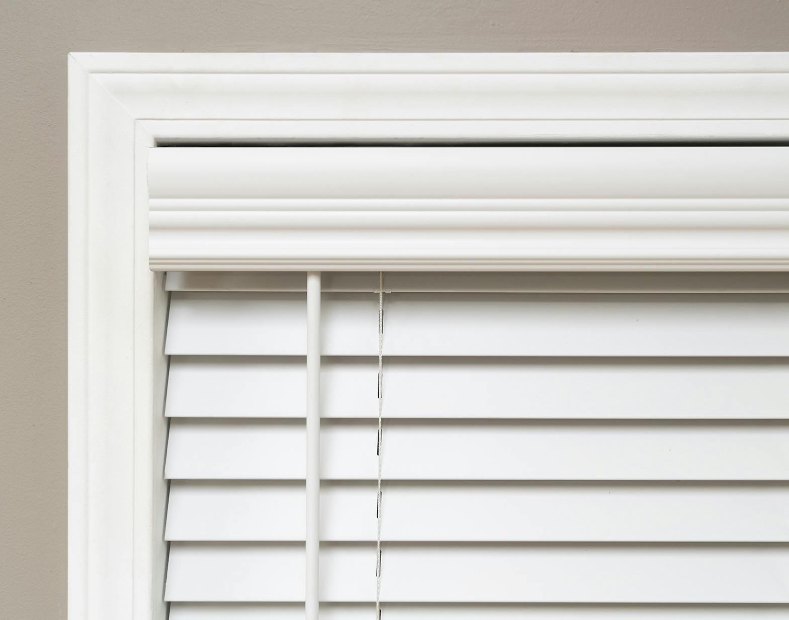 closeup photo of white faux wood blinds