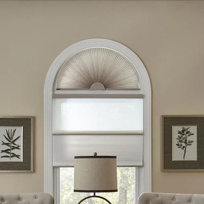 shades covering an arched window in a living room