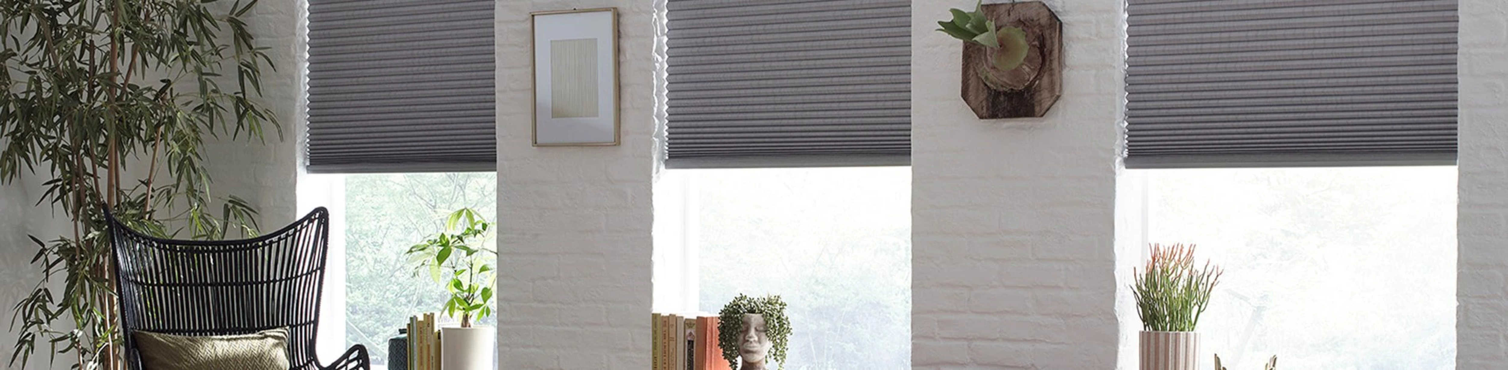 grey cellular shades among white walls in a bright sitting room