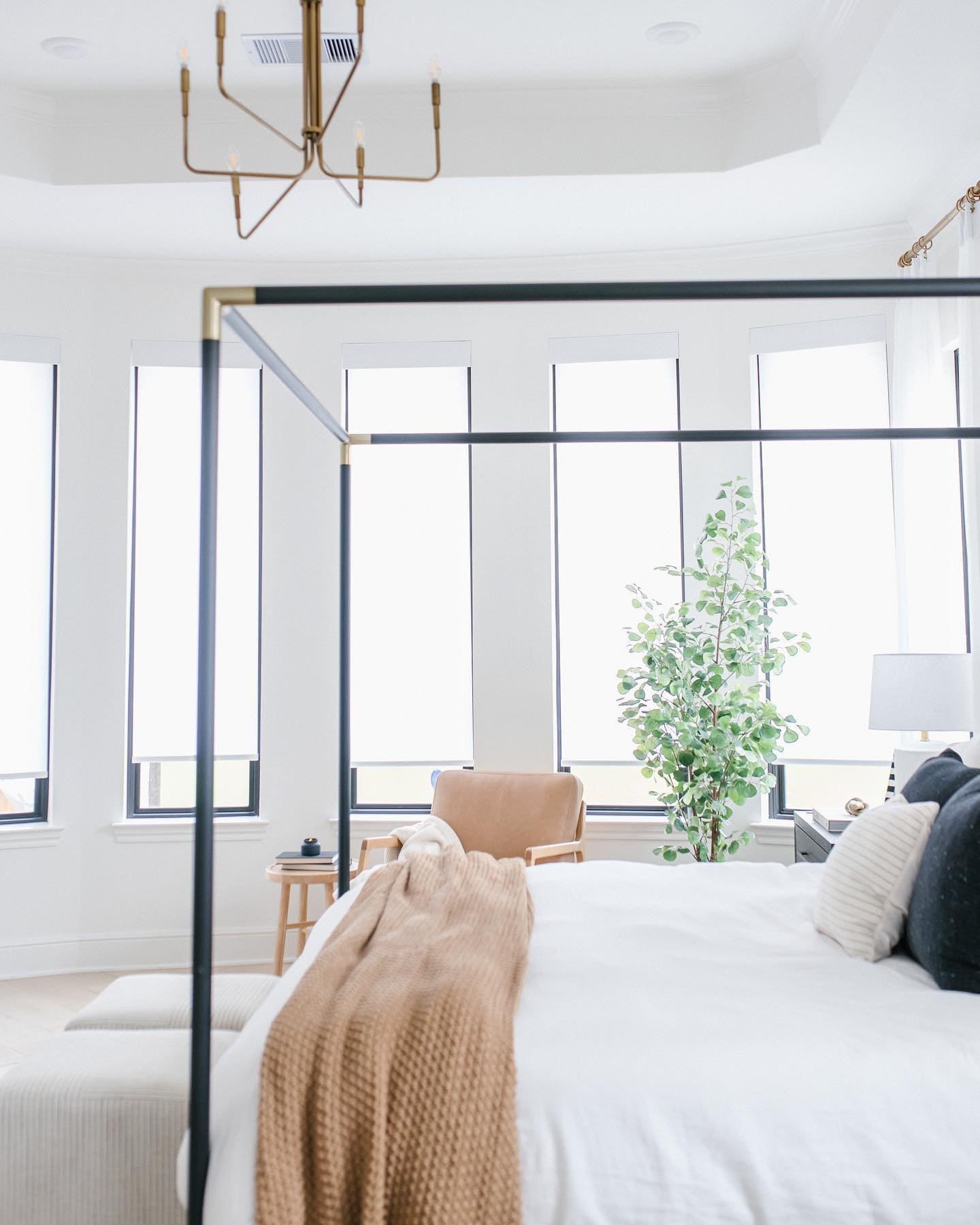 bow window on curved wall in bedroom with white roller shades