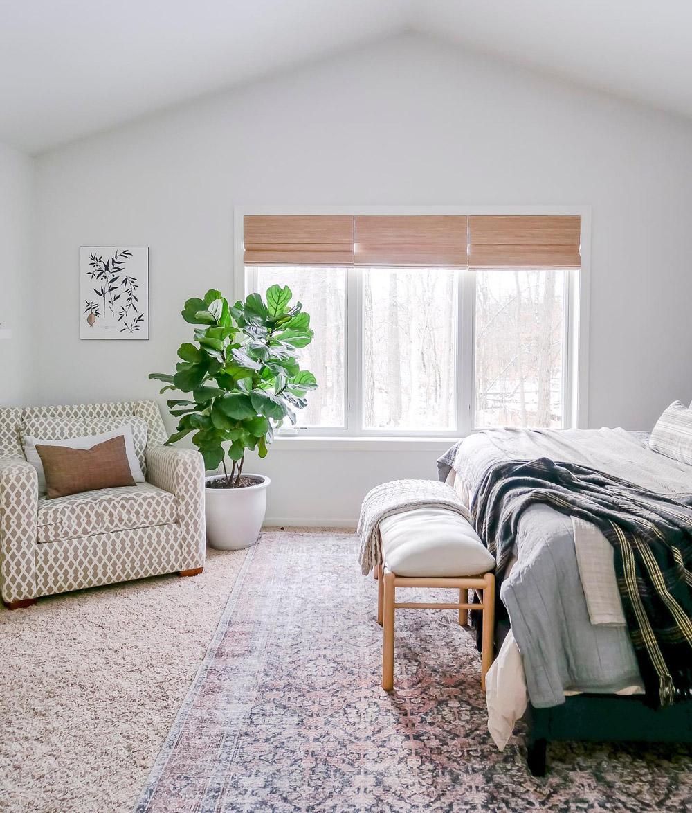 casual bedroom with triple window covered with 3-on-1 headrail woven wood shades