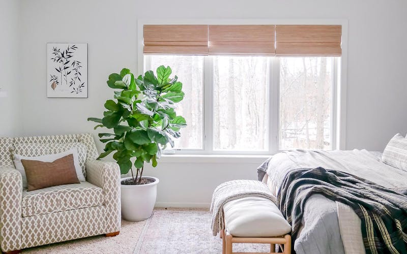 casual bedroom with triple window covered with 3-on-1 headrail woven wood shades