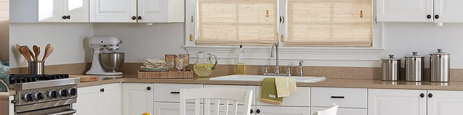 Tan window shades above a kitchen sink in a brightly lit kitchen