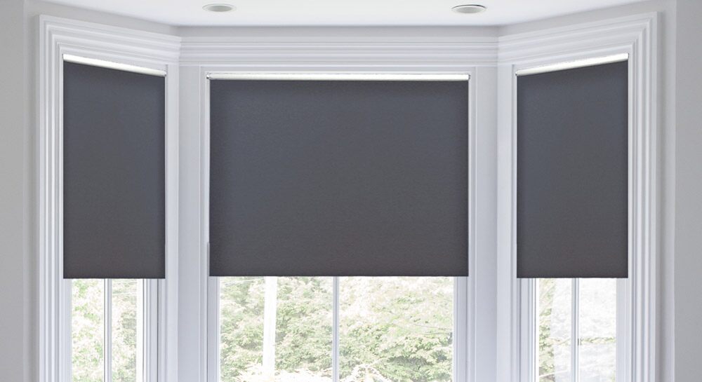 Black shades in a bay window with white frames