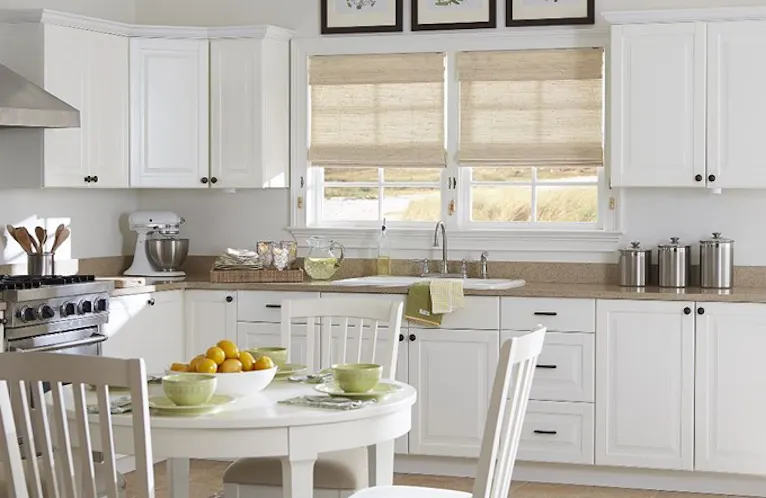 beige bamboo shades in a bright white kitchen