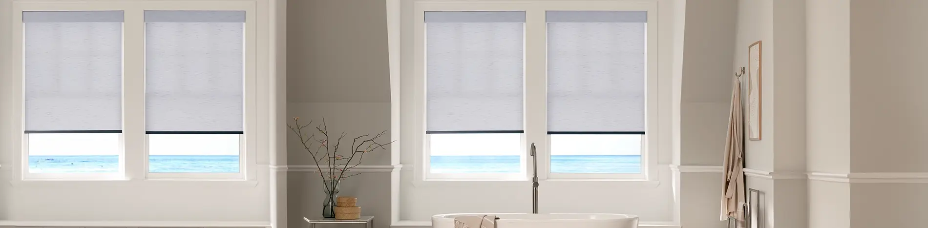 white roller shades in a brightly lit living room facing the ocean